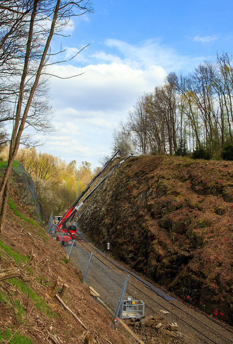 Nun haben die Felssicherungsarbeiten endlich begonnen....
Am 23. Dezember 2022 ca. 18:15 Uhr kam es hier, in Herdorf kurz hinter dem Hp  Knigsstollen (bei km 88,4 der Hellertalbahn KBS 462), zu einem Felssturz und der HLB Triebwagen VT 507, als RB 96 „Hellertalbahn“ entgleiste, verletzt wurde zum Glck niemand. Nun nach ber vier Monaten haben endlich die erforderlichen Sicherungsmanahmen begonnen, hier am 27.04.2023. Zuerst mssen viele 4 m lange Anker in den Fels getrieben werden. Die Arbeiten werden von der Firma FELDHAUS Bergbau GmbH & Co. KG aus Schmallenberg (Hochsauerland) ausgefhrt. 
