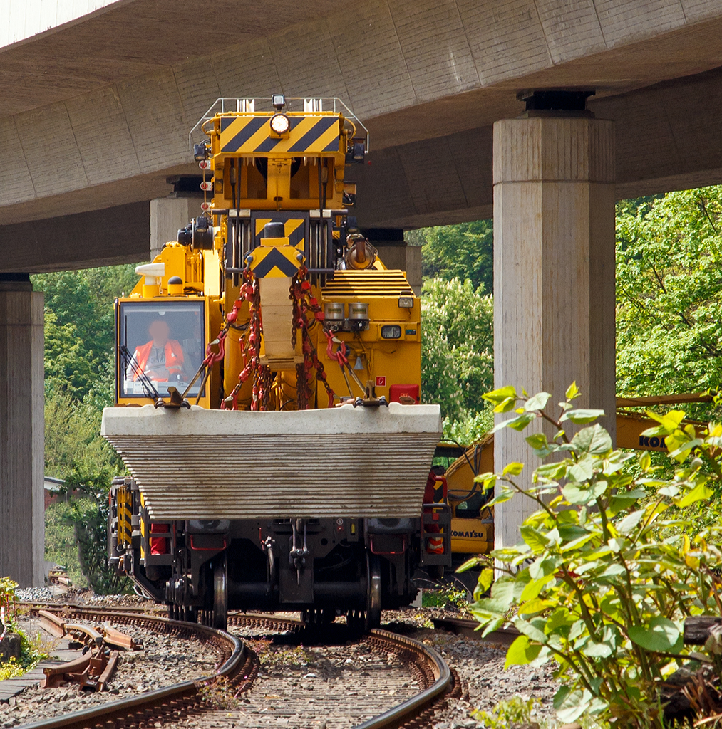
Nun hat der 125t - KIROW Gleisbauschienenkran KRC 810 T der Hering Bau (Burbach), Schweres Nebenfahrzeug Nr. D-HGUI 99 80 9419 010-0, ein Gleisjoch an der Traverse und fährt am 09.05.2015 wieder Richtung Hauptbahnhof Siegen.