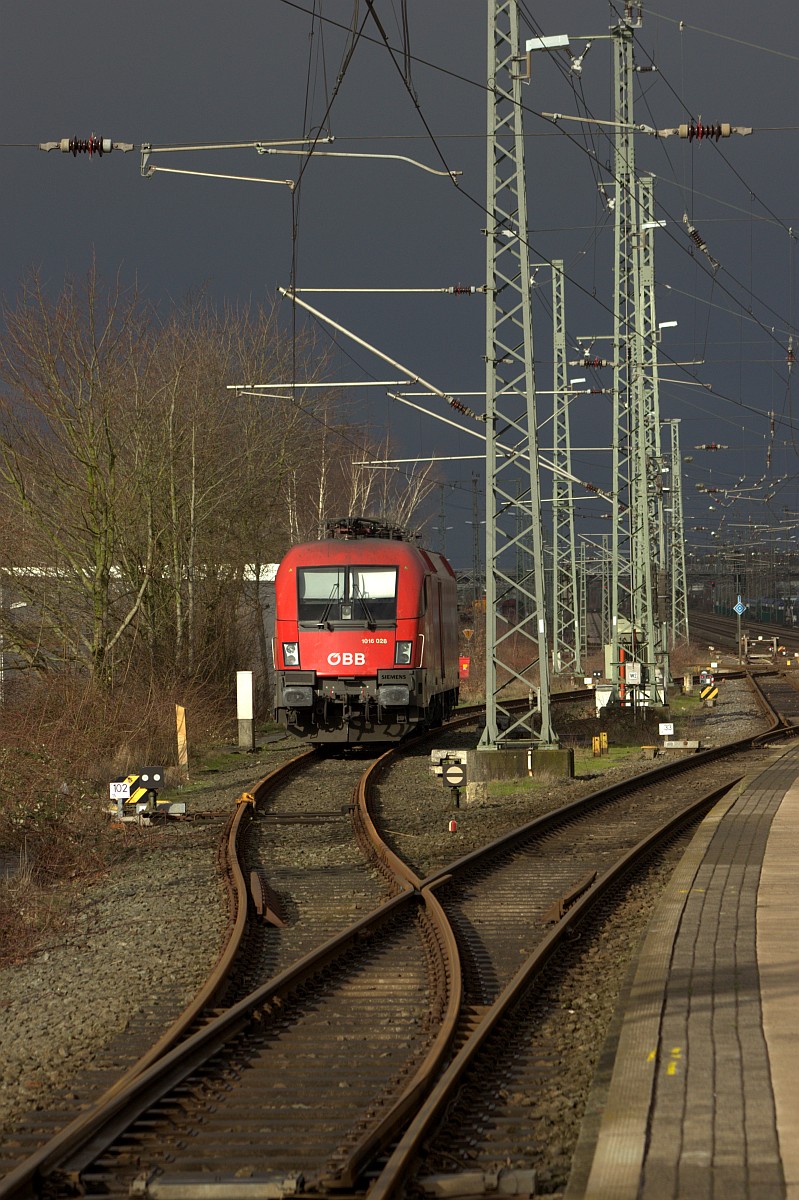 ÖBB 1016 028-3 vor  bedrohlicher  Kulisse abgestellt am Bhf Neumünster. 25.02.2020