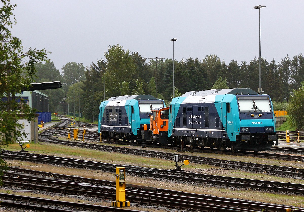 Paribus/NAH.SH 245 201 und 203 stehen zusammen mit einer KöF abgestellt im NOB Bw in Husum(Aufnahme aus dem vorbeifahrenden Zug). Husum 05.09.2015