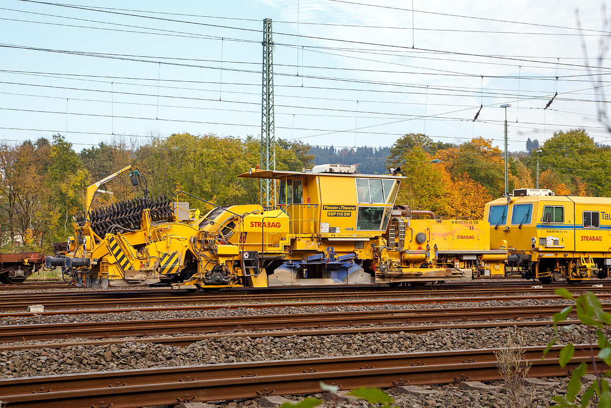 
Plasser & Theurer Schnell-Schotterverteil- und Planiermaschine SSP 110 SW, Schweres Nebenfahrzeug Nr. 99 80 9425 014-4 D-STRA, der STRABAG abgestellt am 23.10.2016 in Betzdorf/Sieg. Dahinter die STRABAG Tauberexxpress eine Stopfexpress CSM 09 – 3X, Schweres Nebenfahrzeug Nr. 99 80 9121 004-2 D-BRS.

Ausrüstung:

- Schottersilo mit 5 m³ Volumen
- hydraulisch verstellbare Schottersilohosen  innen und außen zur Verteilung des Schotters in die Stopfzonen
- Ersatzbesenschwellen für B70 normal, B70 tief und Weichenschwellen
- Kleineisenbürsten
- Querförderband zur Verteilung des überzähligen Schotters nach rechts und links
- höhenverstellbare Bürstenwelle
- Linienleiterabdeckung für Kehrbesen
- Panoramakomfortkabine zur besseren Bedienung


Technische Daten:
Hersteller: Plasser & Theurer
Baujahr: 2011 (Fabriknummer 911)
VDM-Nr.: 99 80 9425 014-4 D-STRA

Motor: wassergekühlter Deutz-Dieselmotor BF 8 M 1015 C, 
aktiver  Rußpartikelfilter
Leistung: 400  kW
max. Geschwindigkeit in Eigenfahrt: 100 km/h
max. Geschwindigkeit in Schleppfahrt: 100 km/h
Eigenfahrtrichtung: beidseitig
Achsanzahl:  2
Sifa / PZB / Zugbahnfunk  (analog /digital):  Ja
Arbeitsgeschwindigkeit: bis 3.000 m/h (Gleis)
Arbeitsweise: kontinuierlich
min. Radius bei Arbeit: 180 m
min. Radius bei Fahrt: 120 m

Fahrzeug: 
Zulassung:  gemäß Richtlinien EBA/DB AG §32
Spurweite: 1.435  mm
Eigengewicht:  43.000 kg
Höhe: 4.255  mm
Breite: 3.000  mm
Länge über Puffer: 17.225 mm
Achsabstand: 8.100 mm
Kraftstoffvorrat (Diesel): 1.040 l
Streckenklasse: D 4 oder höher
