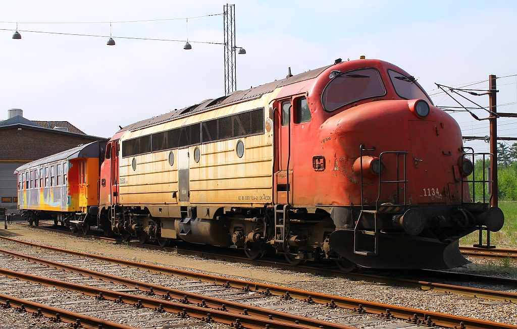 Railcare MY 1134(92 86 0001134-2 DK-RCDK)mit buntem Wagen abgestellt vor den Werkshallen(frei zugänglich)der Railcare Danmark/ApS in Padborg. 01.06.2013