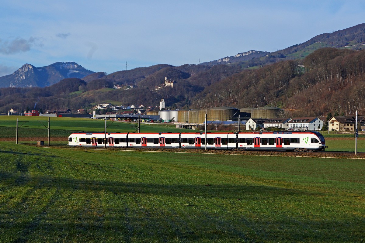 SBB: Morgendliche Winterstimmung vom 21. Dezember 2014 bei Niederbipp. Nur drei Tage vor Weihnachten fehlt noch immer die weisse Pracht. Regionalzug Biel-Olten mit  FLIRT  bei Niederbipp unterwegs vor der Kulisse der ersten Jurakette mit Schloss Bipp und der Evangelisch reformierten Kirche Oberbipp.
Foto: Walter Ruetsch