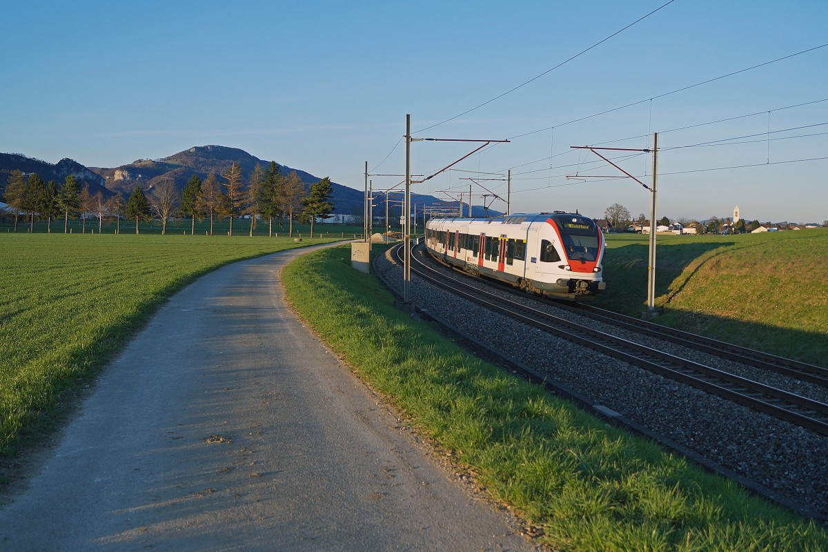 SBB:  STRASSE UND SCHIENE  Ein Flirt als Regionalzug Olten - Solothurn zwischen Niederbipp und Wangen an der Aare am 8. April 2015 im letzten Abendlicht unterwegs.
Foto: Walter Ruetsch