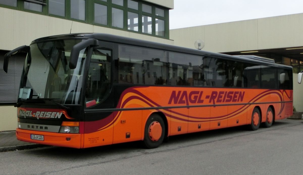 Setra S 319 UL-GT von Nagl-Reisen aus Moosen/Vils bei Taufkirchen/Vils. Er ist aus den Jahrgängen 2005 oder 2006, hat 69+1 Sitzplätze (Ausflugssitze 'Tourist' mit Lederkopfteil und Armlehne) und einen Rollstuhllift am Mitteleinstieg. Als Antrieb dient ein Reihensechszylinder Typ MB OM 457 hLA und ein Sechsgang-Schaltgetriebe, das ebenfalls von MB (Typ GO 210-6) sein dürfte.
Aufnehmen konnte ich ihn hier am 28. 8. 2013 vor dem Bahnhof in Mühldorf/Inn, als er auf einem Schienenersatzverkehr zwischen Mühldorf und Dorfen (Bahnstrecke Mühldorf - München) eingesetzt wurde. Leider wurde dieses Foto etwas unscharf.