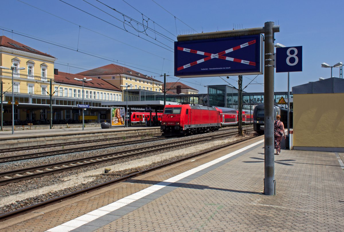 Ungnstigerweise ist die Rheincargo-Lokomotive 185 605 als Leerfahrt gerade in dem Augenblick auf dem Durchfahrgleis in Regensburg unterwegs, als im Hintergrund die Werbe-146 ausfhrt. Letztlich hat es aber fr Bilder beider Lokomotiven gereicht.

Auerdem im Bild: Die  Reisendeninformation der Zukunft , die leider keinerlei Informationen bietet. Allerdings scheint der Testbetrieb noch nicht aufgenommen worden zu sein und das System in Zukunft informativer sein.