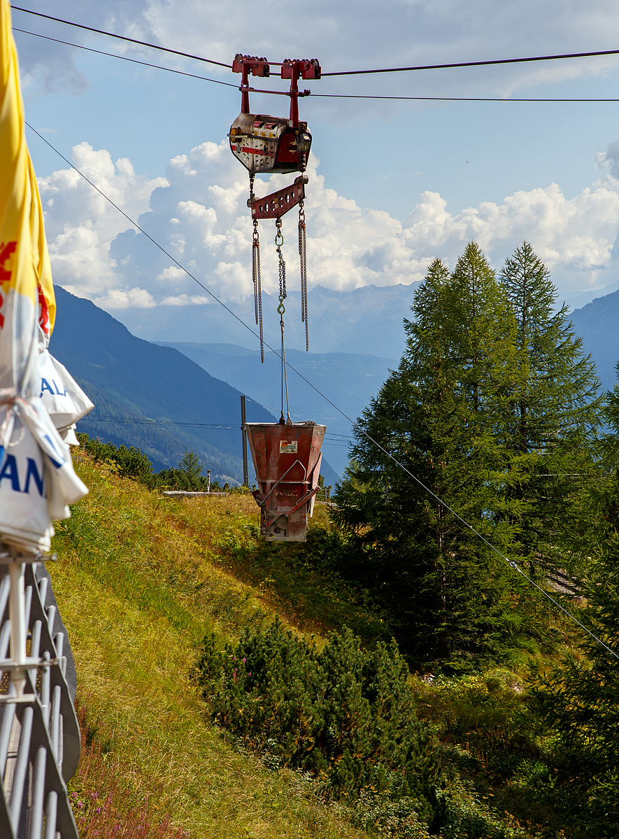 Unterhalb Alp Grüm werden die Alp Grüm der Berninabahn erneuert, daher gibt es eine Materialseilbahn von Alp Grüm hinab zu den Galerien, hier am 06.09.2021. So wird oben in Alp Grüm der Beton gemischt und dann mit der Seilbahn hinab gefahren. 

Die hier verwendete Bahn ist vom italienischen Seilbringungs-Spezialisten Seik (Truden). Der verwendete Wagen ist ein Seilkran vom Typ SFM 30/60.  In dem Seilkran befindet sich ein Verbrennungsmotor der das Hubwerk antreibt (dieser läuft nur bei der Hubbewegen) um wie hier den Betonkübel anzuheben und später wieder abzusenken. Die Hubkraft beträgt im Einzelzug 3t oder wie hier im Doppelzug mit dem Waagbalken 6t. Das Gesamtgewicht beträgt ca. 1t. Die Winde für das Zugseil kann nach Belieben (Bergseite – Talseite) platziert werden.