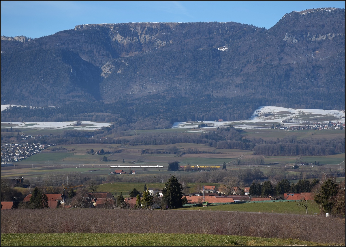 Viel Landschaft, wenig Zug am Jura. 

Zugbegegnung zwischen Bettlach und Selzach. Ein ICN Richtung Solothurn trifft auf einen Postzug mit einer Re 4/4 II. Januar 2022. 