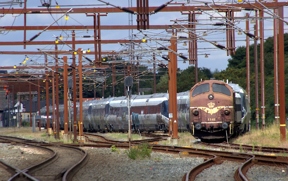 Vom Bahnbergang in Tinglev aus aufgenommen...SRP Litra MY 1148 mit ihrem Zug bestehend aus RailAdv Habfis + 9x IC2 + RailAdv Habfis in Warteposition am Bhf in Tinglev. 08.08.2022