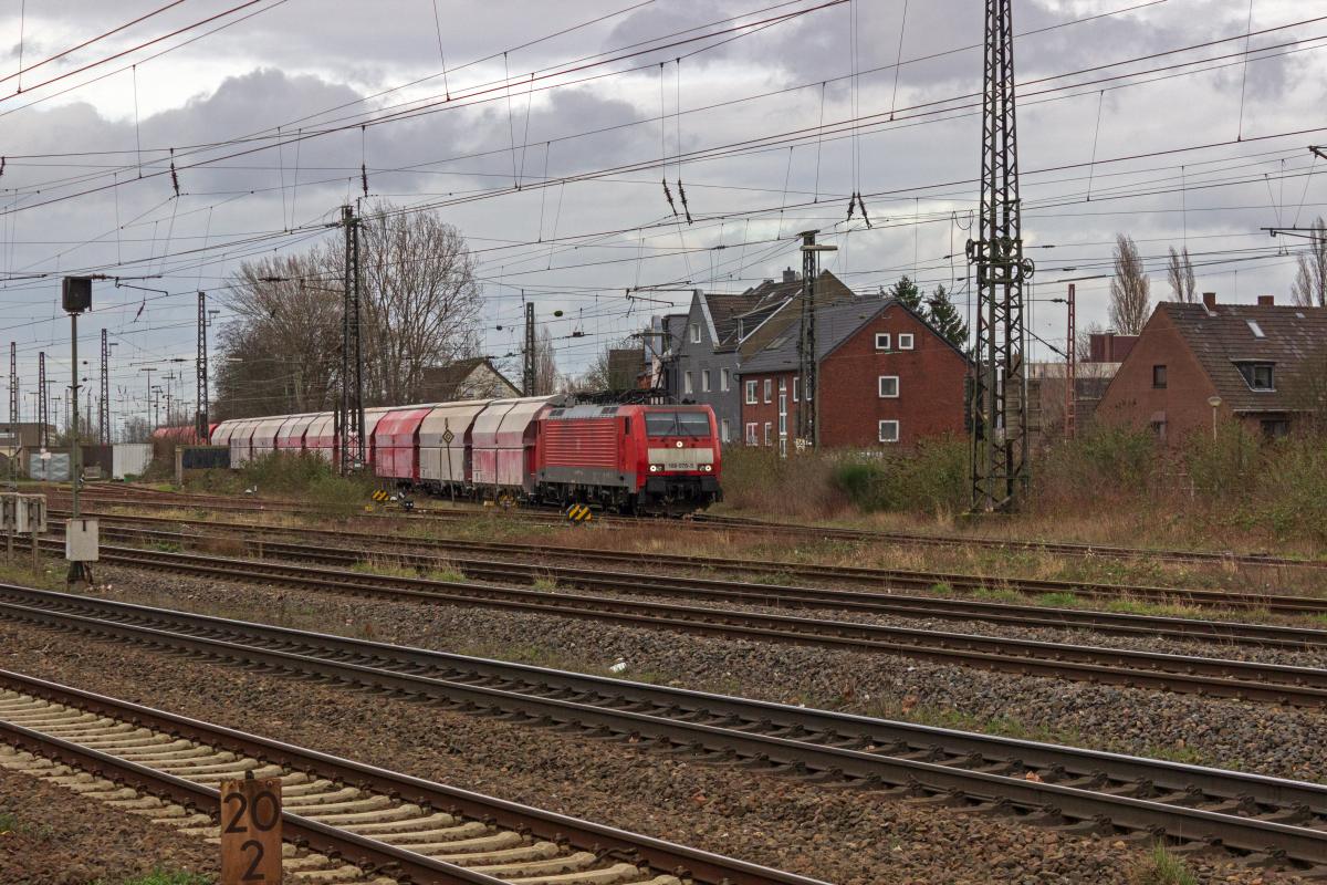 Weithin erkennbar sind die im Kalkverkehr eingesetzten Selbstentladewagen durch die groflchigen weien Ablagerungen. Auf dem Weg in Richtung Niederlande verlsst 189 075 die Ausfahrgruppe des Gterbahnhofs Oberhausen-Osterfeld, dessen ausgedehnte Gleisanlagen sich bis in das benachbarte Bottrop erstrecken.