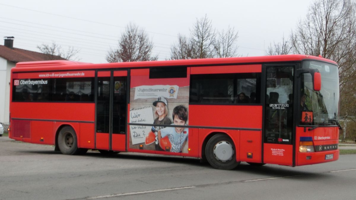 Wie mehrere Busse seiner Flotte hat Hinmüller Reisen aus Oberflossing bei Polling diesen Setra S 315 UL im Design der RVO / DB Oberbayernbus gestaltet und mit einer Werbefolie der Jugendfeuerwehr versehen. Dieses Exemplar ist bei Setra im Jahr 2000 vom Band gelaufen und hat 55 Fahrgastsitzplätze (mit kippbarer Sitzbank am Mitteleinstieg; Setra-Überlandbestuhlung Modell Special-Class mit Sicherheitsgurten) plus 2 Reiseleitersitze. Vorne, rechts und hinten ist jeweils eine LAWO-Matrix eingebaut. Der Antriebsstrang besteht aus dem Reihensechszylinder Typ MB OM 447 hLA mit 184 kW (250 PS) und dem Sechsgang-Handschaltgetriebe ZF S 6-85.
Abgelichtet wurde der Bus am Mittag des 10. 12. 2014 an der Wendeschleife vor der Inn-Apotheke in Kraiburg/Inn, als er aus Waldkraiburg kommend auf der RBO-Linie 6224 Kurs 034 unterwegs war.