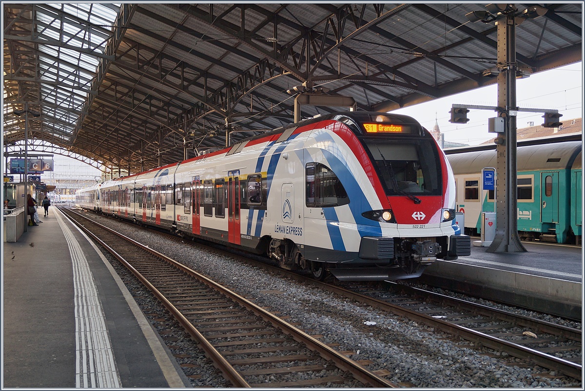 Zwei SBB RABe 522 in  Léman Express  Gestaltung warten in Lausanne auf die Abfahrt nach Grandson. Im Hintergrund gerade noch zu erkennen, ein Schlafwagen des EN 200 Thello.
1. Juni 2018