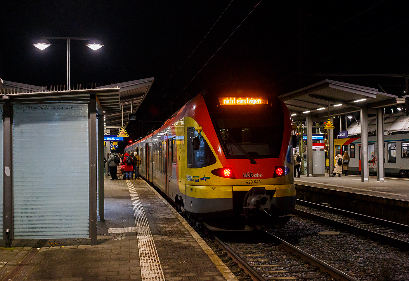 Am 13 Januar 2025 fuhren wir früh morgens um 05 Uhr 28 ab dem Bahnhof Herdorf mit dem HLB RB 96 „Hellertalbahn“ in Richtung Salzburg los. Es war wieder eine Reise mit viel Chaos.

Unser Reiseplan war wie folgt:
Mit HLB RB 96 von Herdorf ab 05:28 nach Haiger an 06:08
Mit HLB RE 99 von Haiger ab 6:20 nach Frankfurt(Main)Hbf an 08:00
Mit DB/ÖBB EC 113 Frankfurt(Main)Hbf ab 08:21 nach Salzburg an 13:59

Auf halber Strecke hatte unser Triebwagen (ein LINT 27) in Burbach schon starke Druckluftverluste (was wohl an den frostigen Temperaturen lag), so kamen wir mit etwas Verspätung nach Haiger. Von Haiger ging es dann mit dem HLB RE 99 weiter, es war der fünfteilige FLIRT 429 043/429 543, der mit mächtig viel Bügelfeuer fuhr. Der ET war später komplett gefüllt, selbst fast alle Stehplätze waren ausgenutzt. 

In der weltweit durch Leitz und Leica bekannten Stadt Wetzlar war aber dann erst mal Schluss. Eine Weiterfahrt in Richtung Gießen bzw. Frankfurt/Main war bis 8 Uhr nicht möglich, da das Stellwerk Dutenhofen bis dahin wegen Personalausfall nicht besetzt war. So mussten wir hier aussteigen, der der HLB Flirt fuhr als RE 99 einfach wieder zurück nach Siegen. Wir nahmen es, wie nur einige wenige Reisende, gelassen (Take it easy) und holten uns erstmal einen Kaffee. 

Hier der fünfteilige FLIRT HLB 429 043/429 543 für den, als RE 99 „Main-Sieg-Express“ in Wetzlar Schluss war. So fuhr er weniger Minuten später als RE 99 in die Gegenrichtung nach Siegen Hbf. 
