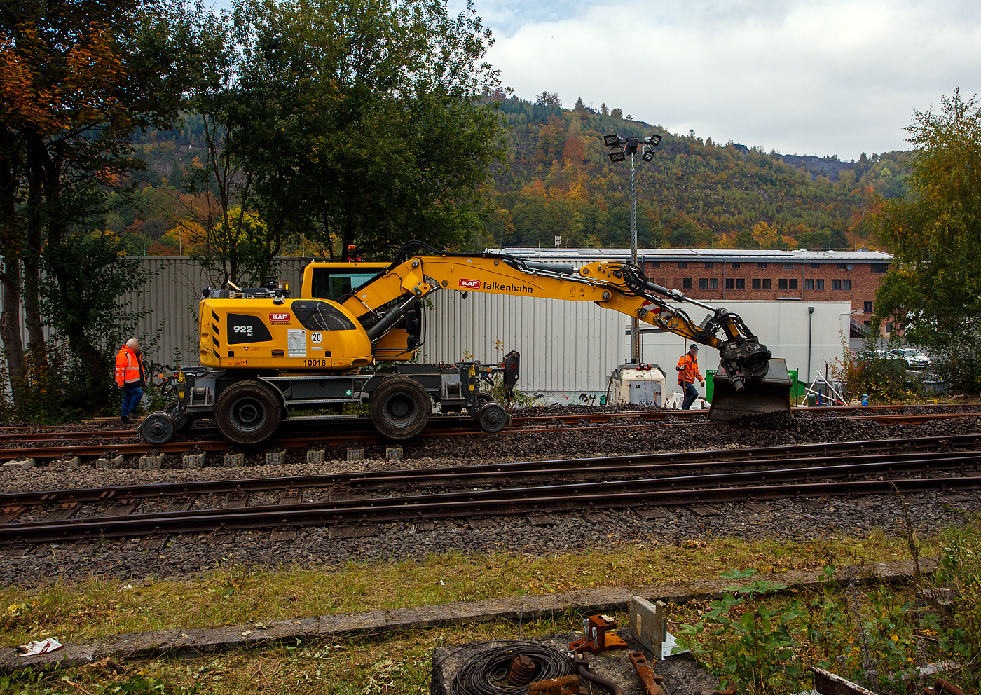 Baustelle Bahnhof Herdorf am 12 Oktober 2025, nun werden die Weichen 25 und 26 eingeschottert. 

Der Liebherr Zweiwegebagger A 922 Rail Litronic mit Abstützpratzen, Kleinwagen Nr. D-KAF 99 80 9904 795-8 (KAF Interne Nr. 10016), der KAF Falkenhahn Bau AG (Kreuztal) muss aushelfen und den Schotter etwas verteilen. Das geht viel schneller als mit Muskelkraft. 