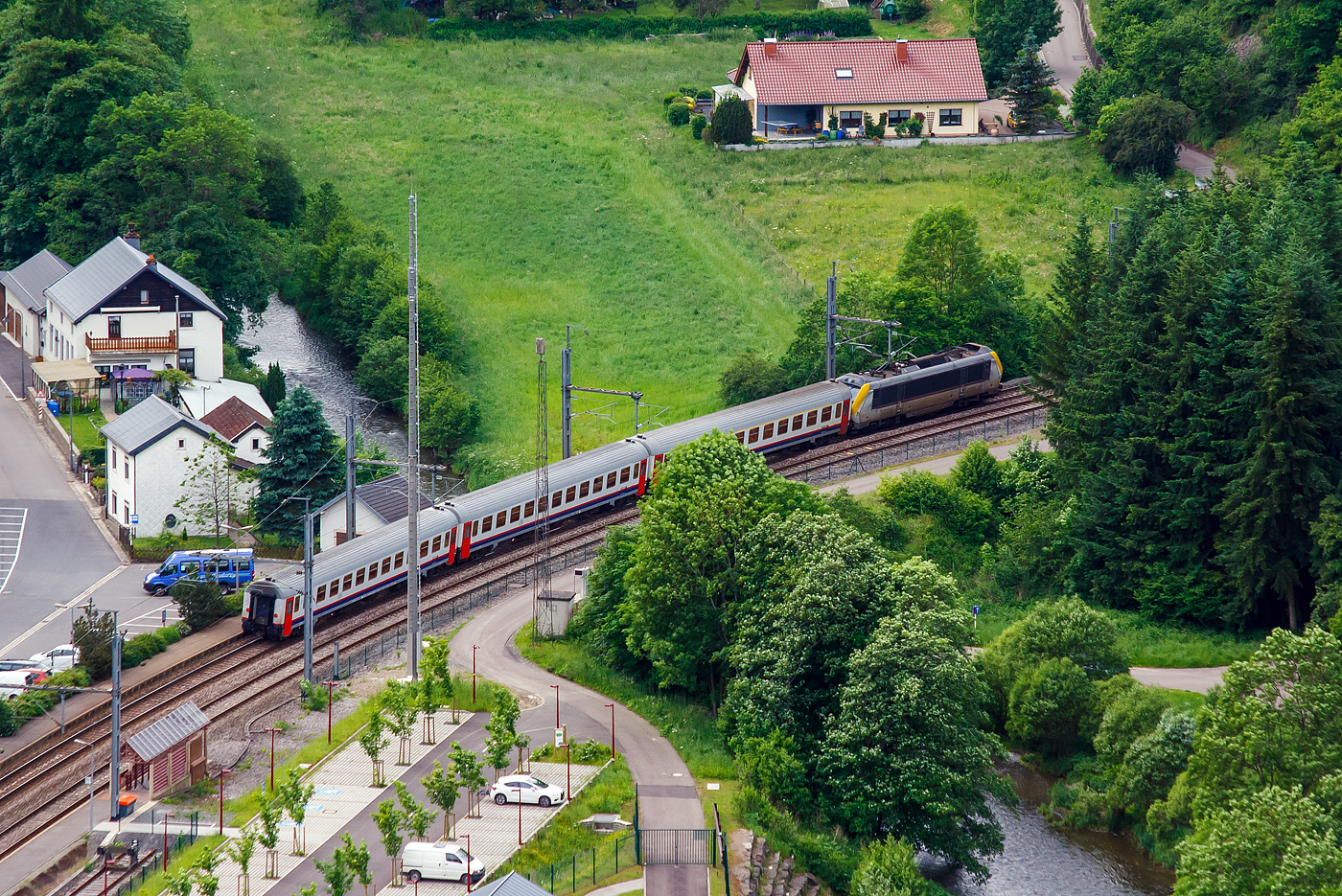 Blick von der Hockslay, die CFL 3006 hat am 15 Juni 2013 mit 3 belgischen I11 Reisezugwagen als IR von Luxembourg über Troisvierges und Liège (Lüttich) nach Liers(B) den Bahnhof Kautenbach (Kautebaach) verlassen und überquert hier gerade das Flüsschen Wiltz (Wolz). Die Wiltz ist ein Nebenfluss der Sauer. 