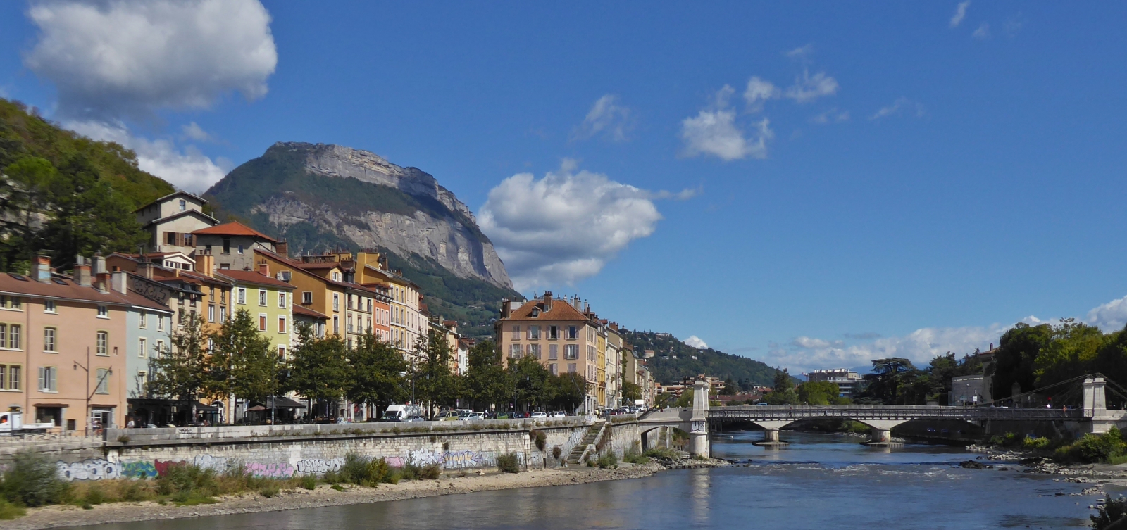 Blick über die Isère in Grenoble auf die „Passerelle Saint Laurent“ und den „Pont de la Citadelle“ mit dem Imposanten Berg im Hintergrund. 09.2022