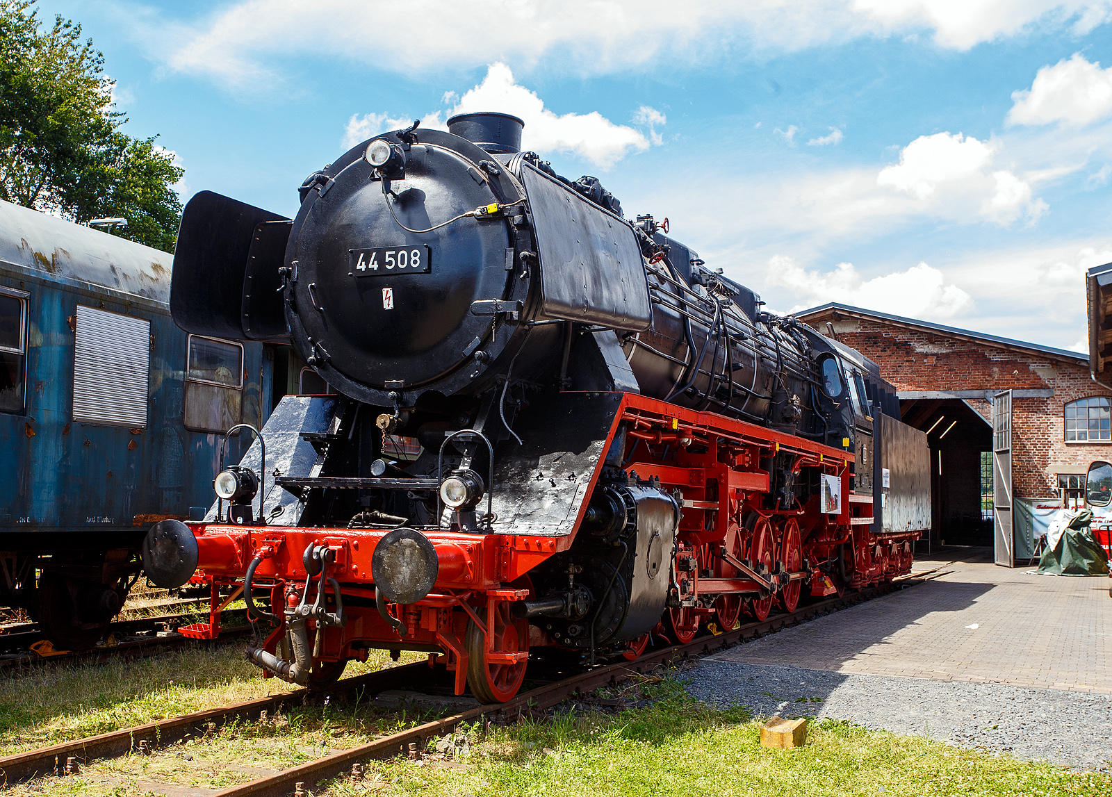 Der „Jumbo“ bzw. die schwere kohlegefeuerte fünffachgekuppelte Dreizylinder-Güterzug-Dampflokomotive 44 508, ex DB 044 508-0, am 07 Juli 2024 ausgestellt beim Lokschuppen vom Erlebnisbahnhof Westerwald der Westerwälder Eisenbahnfreunde 44 508 e. V. hier war Lokschuppenfest.

Nun erstrahlt sie im vollen Glanz, auch die Treib- und Kuppelstangen sind nun wieder montiert.

Die Dampflokomotive 44 508 wurde im Jahr 1941 von der Lokomotivfabrik Krauss-Maffei in München unter der Fabriknummer 16113 gebaut und an die DR geliefert. Nach dem Krieg blieb sie im Westen und wurde so 1949 als 44 508 in den Bestand der Deutsche Bundesbahn aufgenommen, mit der Einführung des EDV-Nummernschemas wurde sie zum 01.01.1968 in 044 508-0 umgezeichnet. Seit Mitte der 1950er Jahre ist sie gekuppelt mit dem 2'2'T34 Tender der ex ÖBB 44 1561 (Borsig Lokomotiv-Werke GmbH, Hennigsdorf-Berlin, Baujahr 1940, Fabriknummer 15400). Bis zu ihrer Außerdienststellung im Mai 1977, im BW Gelsenkirchen-Bismarck legte sie eine Strecke von über 1.9 Millionen Kilometern zurück.

Die Maschine verfügt über ein Drei-Zylinder-Triebwerk, fünf Antriebsachsen und einen Schlepptender, in dem sie 10 Tonnen Kohle und 34 Kubikmeter Wasser mitführen kann. Sie erreicht eine maximale Leistung von 1.910 PS bei einem Dienstgewicht von 160 Tonnen. 

Die 44 508 wurde im Mai 1977 beim Bahnbetriebswerk Gelsenkirchen-Bismarck außer Dienst gestellt. Die 44 508 ist eine der letzten erhaltenen Dampflokomotiven ihrer Bauart. Sie wurde im Jahr 1987 durch eine Freizeitgruppe des Bahn-Sozialwerkes (BSW) übernommen. Damit begann die museale Aufarbeitung der Lok, die im Jahre 2002 jedoch unterbrochen wurde, als das Domizil in Siershahn geräumt werden musste. Der Verein Westerwälder Eisenbahnfreunde übernahm diese Dampflokomotive als Leihgabe des DB Museums, auch wenn sie nie im Westerwald eingesetzt war.
