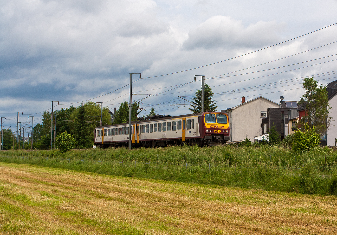 Der CFL 2010, ein CFL Z2 – CFL Série 2000, fährt am 15 Juni 2013 auf der Nordstrecke (Bahnstrecke Luxemburg–Spa), hier bei Lintgen in Richtung Luxemburg. Mein Bild entstand einen Moment früher, als das schöne Bild von Stefan http://hellertal.startbilder.de/bild/luxemburg~triebzuege~srie-2000-z-2/902123/bei-lintgen-ist-der-cfl-z2.html  Ich war etwas vorgelaufen und in einen Seitenweg ausgewichen, so entstand ein anderer Blickwinkel auf den gleichen Zug. 

Übrigens die Bilder ist nun auch schon „historisch“ bis Ende dieses Jahres (2025) sollen 20 der 21 noch vorhanden Z2 Luxemburg in Richtung Rumänien verlassen haben. Lediglich das Triebzug CFL 2021 verbleibt bei der CFL als Teil des Eisenbahnerbes Luxemburgs. Die 20 Triebzüge wurden von dem Unternehmen Ferotrans TFI (ein neuer Akteur auf dem rumänischen Markt) übernommen. So dürfen sie wohl nach 35 Jahren in Luxemburg im Einsatz noch weitere Jahre in Rumänien fahren.

In der Zentralwerkstatt der CFL erhielten die Triebwagen dafür nochmals ein Reengineering und einen letzten Feinschliff so sind die Z2 nun bereit für ein neues Leben in Rumänien.
