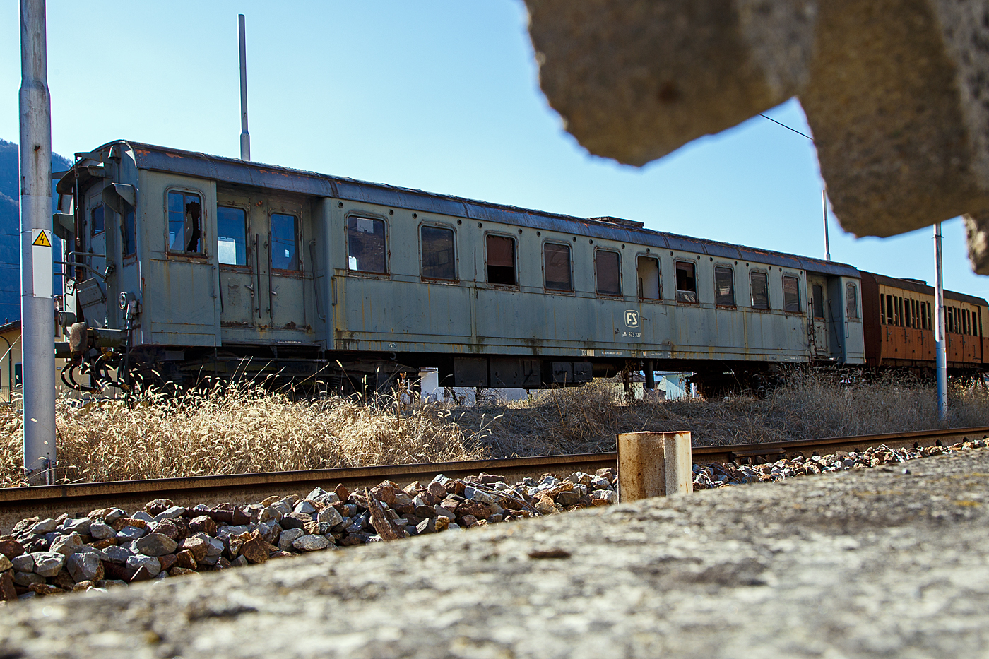 Der FS pBz 623 327 ein Steuerwagen zu den Triebwagen der Baureihen E.623 (Automotrice elettrica E.623 - Rimorchi pBz 623) abgestellt am 19 Februar 2017 in Tirano, leider hier im Gegenlicht. Hätte ich damals gewusst was ich hier aufgenommen habe, so wäre ich am Nachmittag nochmal dort hingegangen. 

Die schweren Elektrotriebwagen E.623 der italienischen Ferrovie dello Stato (FS) waren Elektrotriebwagen, die anfangs der 1950er Jahre aus den für die Ferrovie Varesine gebauten Triebwagen der Baureihen E.10 und E.60 umgebaut wurden. Auch die zugehörigen Steuerwagen (eCiz 300-342)
wurden zu pBz 623 327 – 342 umgebaut, die 3. Wagenklasse wurde dabei in die 2. Wagenklasse geändert. 

Die ursprünglich für den Betrieb mit 650 V Gleichstrom aus der Stromschiene gebauten Fahrzeuge erhielten die Triebwagen nun zwei Scherenstromabnehmer auf dem Dach für Stromaufnahme aus der Oberleitung, zudem angepasste elektrische Ausrüstung, damit sie auf den nun mit 3 kV-Fahrleitung elektrifizierten Strecken verkehren konnten. Durch den Umbau vergrößerte sich auch das Einsatzgebiet der Varesine genannten Triebwagen. Sie verkehrten außerhalb ihrer Stammstrecke auch von Mailand nach Domodossola, Bergamo und Novara, sowie auf der Strecke von Novara nach Alessandria. Weiter wurden von Novara aus auch Luino und Arona, sowie auf der Strecke Seregno–Carnate mit Varesine bedient. Zwei Triebwagen sind im historischen Fahrzeugpark der FS-Stiftung erhalten.

TECHNISCHE DATEN (Steuerwagen pBz):
Ur-Baujahre: 1931 bis 1932
Hersteller: Breda - CGE
Spurweite: 	1.435 mm (Normalspur)
Achsformel: 2'2' 
Länge über Puffer: 21.050 mm 
Drehzapfenabstand:  14.200 mm
Achsabstand im Drehgestell: 2.500 mm
Laufraddurchmesser: 1.010 mm (neu)
Eigengewicht: 41 t
Höchstgeschwindigkeit: 120 km/h (ursprünglich 110 km/h)
Sitzplätze: 70 (in der 2. Klasse)
Bremse: Freno WU-P
