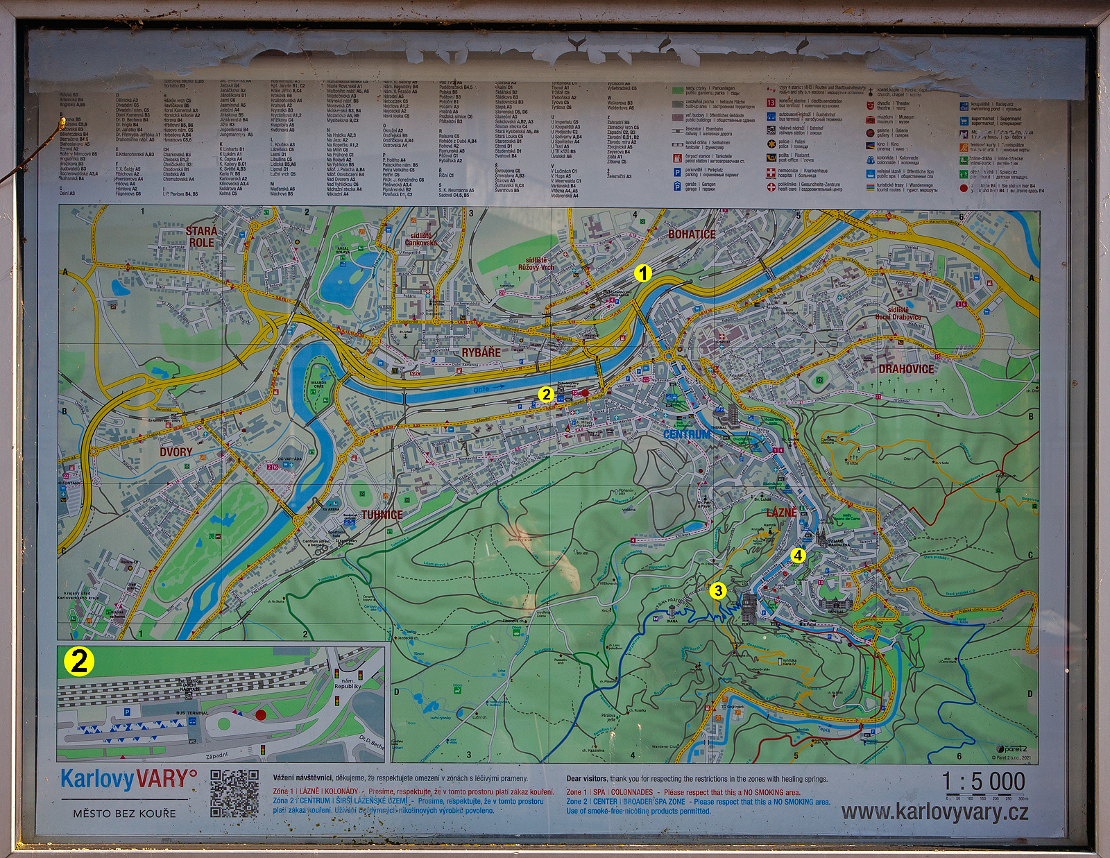 Der Stadtplan der tschechischen Stadt Karlovy Vary (Karlsbad), hier aufgenommen am 21 April 2023 beim unteren Bahnhof (Karlovy Vary dolní nádraží).

Die vier wichtigen Bahnpunkte habe ich gesetzt, es sind:
1 = 
Karlovy Vary (Karlsbad, oberer Bahnhof bzw. Karlsbad Hbf), er liegt an der elektrifizierten Hauptbahn Ústí nad Labem–Chomutov–Cheb, ursprünglich von der k.k. priv. Buschtěhrader Eisenbahn (BEB) gebaut. Dort zweigen auch die Strecken der Nebenbahnen nach Johanngeorgenstadt (D) vorm. Eisenbahn Karlsbad–Johanngeorgenstadt) und nach Mariánské Lázně (Marienbad) vorm. EB Marienbad–Karlsbad ab. Im nahen Dalovice hat die Strecke nach Merklín ihren Ausgangspunkt. Von Karlsbad bestehen Fernverbindungen über Pilsen nach Prag und Košice. Mit Regionalzügen sind Cheb, Chomutov, Zwickau, Johanngeorgenstadt, Marienbad und Merklín direkt erreichbar.

2 = 
Karlovy Vary dolní nádraží (Karlsbad unterer Bahnhof), ist der zweite Bahnhof in der Stadt, er ist Ausgangspunkt der Nebenbahnstrecke, über Bečov nad Teplou (früher Petschau) nach Mariánské Lázně (Marienbad), der ehemaligen EB Marienbad–Karlsbad. Zudem ist er auch direkt mit dem oberer Bahnhof bzw. Karlsbad Hbf verbunden, und Regionalzügen fahren von hier über den Hbf nach Johanngeorgenstadt in Sachsen.
Unten rechts nochmal vergrößert im Ausschnitt auch Karlovy Vary dolní nádraží.

3 = 
Lanová dráha Diana (Standseilbahn Diana)
Die Diana-Standseilbahn wurde am 5. August 1908 eröffnet und beginnt an der Station Alte Wiese (Stará louka), gleich neben dem Grandhotel Pupp in der Gasse Mariánská, auf einer Höhe von 389 m und führt auf die Freundschaftshöhe 556 m über NN, wo sich der Diana-Aussichtsturm befindet. Die 167 m Höhenunterschied überwindet sie auf einer Strecke von 437 m. Im Bereich der Ausweiche Hirschensprung (Jelení skok) in 473 m Höhe liegt auch die Zwischenstation. Die maximale Steigung beträgt 432,3 ‰, durchschnittlich liegt diese bei 398,1 ‰. 

4 = 
Lanová dráha Imperiál (Standseilbahn Imperial)
Die erste Standseilbahn in Karlsbad ist die am 18. Mai 1907 eröffnete meterspurige Bahn vom Theaterplatz (tschechisch Divadelní náměstí) zum Café Helenenhof (tschechisch Helenin dvůr) am Hotel Imperial. Sie beginnt in einer Höhe von 381 m und führt über eine 127 m lange Strecke auf eine Höhe von 437 m. Sie hat an der steilsten Stelle eine Steigung von 495 ‰. Die Bahn besitzt eine Ausweiche und verläuft vollständig unterirdisch.

1980 wurde die Bahn aufgrund ihres schlechten Zustandes zunächst stillgelegt. Zwischen 1983 und 1987 erfolgten Renovierungsarbeiten, und die Wiedereröffnung fand am 28. November 1987 statt. Die Bahn ist seit dem 1. August 1961 Bestandteil des öffentlichen Personennahverkehrs in der Stadt und wird im 15-Minuten-Takt befahren. Die Fahrzeit beträgt 70 Sekunden. Aufgrund der Lage der Talstation in einer Häuserzeile kann sie von Ortsunkundigen leicht übersehen werden.