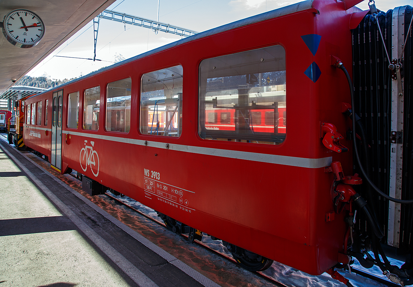 Der vierachsige Velowagen (Fahrradtransportwagen) RhB WS 3913, ex RhB B 2339 am 20 Februar 2017 im RhB Bahnhof St. Moritz.

Der Wagen wurde 1956 von SIG (Schweizerische Industrie-Gesellschaft) in Neuhausen am Rheinfall gebaut. Diese Wagenserie von 13 Stück SIG-Leichtstahlwagen mit Mitteleinstieg (AB⁴ü 1513-1518 und die B⁴ü 2334–2340) wurde, kurz nach Abschaffung der dritten Klasse, von 1956 bis1957, an die RhB geliefert. Diesmal kamen die Wagen aber von SIG Neuhausen (und nicht von SWS) und wiesen viele Gemeinsamkeiten mit den Leichtmetallwagen gleicher Provenienz auf: Flügeltüren, WC beim Mitteleinstieg, Stirnwandtüren direkt im Personenabteil, gleicher Sitzteiler. Die Wagen waren aber 18,22 m lang, liefen auf SIG-Torsionsstab-Drehgestellen (System Frei) und wiesen von Anfang an eine leichte Polsterung in der 2. Klasse auf. Je drei Wagen erhielten zusätzlich Gleichstromheizung für den Einsatz nach Arosa. Zwei Wagen (1517–1518) hatten eine Zeit lang ein Bremszahnrad für den Einsatz bis Brig. 

Zwischen 1989 und 1991 baute die RhB die 1956 in Dienst gestellten Mitteleinstiegswagen AB 1514-1518 und B 2337-2340 zu Pendelzugwagen um und bediente damit hauptsächlich die Strecken Davos-Filisur sowie Samedan-Pontresina im Oberengadin. Sie erhielten anstelle der beiden zweiflügeligen Falttüren moderne Schwenkschiebetüren.

Ab 2000 baute die RhB einige dieser Wagen (dieser 2003) zu Velowagen um. Im Gebiet Engadin wird der Velosport durch die Tourismus-Organisationen sehr stark gefördert. Dies hat auch zur Folge, dass der Velotransport per Bahn zugenommen hat. Der bestehende Stauraum im Gepäckabteil hat oft nicht mehr genügt.

TECHNISCHE DATEN:
Baujahr und Hersteller: 1956 - SIG
Spurweite: 1.000 mm
Anzahl der Achsen: 4
Länge über Puffer: 18.220 mm
Drehgestellbauart: SIG Torsionsstab
Sitzplätze: 56
Eigengewicht: 17,0 t
zulässige Geschwindigkeit: 90 km/h
Lauffähig: StN (Stammnetz) / MGB (Matterhorn Gotthard Bahn)