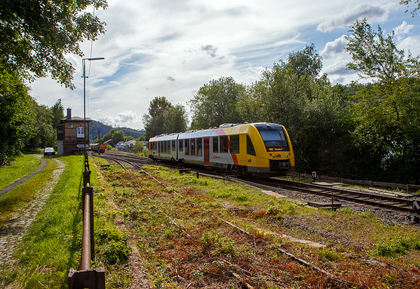 Der  VT 502 (95 80 1648 102-9 D-HEB / 95 80 1648 602-8 D-HEB) ein Alstom Coradia LINT 41 der neuen Generation der HLB (Hessische Landesbahn GmbH) erreicht am 12.07.2023 bald den Bahnhof Herdorf. Er fährt als RB 96 Hellertalbahn (Dillenburg – Haiger - Neunkirchen - Herdorf – Betzdorf/Sieg).

Hinten auf Gleis 2 muss die KSW 44 (92 80 1271 004-4 D-KSW) eine MaK G 1000 BB der KSW (Kreisbahn Siegen-Wittgenstein), mit einem Coilzug noch warten...