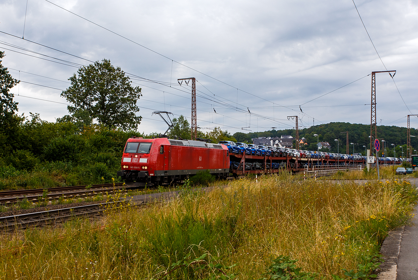 Die 185 058-5 (91 80 6185 058-5 D-DB) der DB Cargo AG fährt am 11 Juli 2024 mit einem langen beladen Autotransportzug (Wagen der Gattung Laaeks 553 der DB Cargo Logistics GmbH, ex ATG), durch Wilnsdorf-Rudersdorf (Kreis Siegen) in Richtung Siegen bzw. Kreuztal.

Nochmals einen lieben Gruß an den netten grüßenden Lokführer zurück, mich freuen immer die Grüße.

Die TRAXX F140 AC1 wurde 2002 von Bombardier in Kassel unter der Fabriknummer 33467 gebaut.
