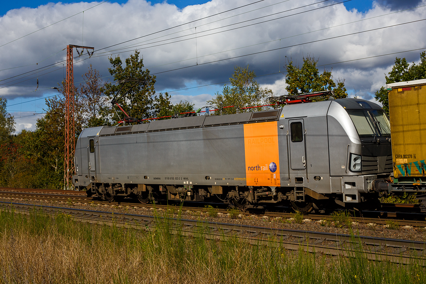 Die 193 922-2 (91 80 6193 922-2 D-NRAIL)  der Northrail GmbH fährt am 05 September 2024 mit einem KLV-Zug durch Wilnsdorf-Rudersdorf (Kr. Siegen) in Richtung Siegen,

Die Siemens Vectron AC wurde 2010 von SIEMENS in München-Allach unter der Fabriknummer 21695 gebaut und auf der InnoTrans 2010 in Berlin präsentiert. Sie war ursprünglich eine Vorführ-/Mietlok der Siemens Mobility in München, eingestellt durch die RailAdventure GmbH als 91 80 6193 922-2 D-RADVE. Im Jahr 2012 wurde sie durch SIEMENS umgebaut, dabei erhielt sie temporär eine Last-Mile Dieseleinheit und wurde in 91 80 6192 961-1 D-PCW umgezeichnet (damals war die BR 192 noch frei). So wurde sie, als Vectron mit LM auf der InnoTrans 2012 in Berlin präsentiert. Im Dezember 2012 wurde sie dann in die Vectron AC Variante B03 (D / A / H) zurück gebaut und zur 91 80 6193 922-2 D-PCW umgezeichnet.

Im Dezember 2013 die Paribus Rail Portfolio III GmbH & Co. KG (Hamburg) verkauft und in die Vectron AC Variante B06 für Schweden umgebaut und über Railpool als 91 80 6193 922-2 D-Rpool eingestellt und wurde an die SkJb - Skandinaviska Jernbanor AB nach Schweden vermietet, später war sie für die Hector Rail AB in Schweden unterwegs. 

2018 ging sie dann wieder nach Deutschland und wurde durch Siemens in München in die heutige Vectron AC B01 Variante (Zulassung Deutschland und Österreich) umgebaut und in 91 80 6193 922-2 D-NRAIL umgezeichnet. Eigentümer ist die Paribus Rail Portfolio III GmbH & Co. KG, die die LOKS für die Northrail GmbH finanziert.
