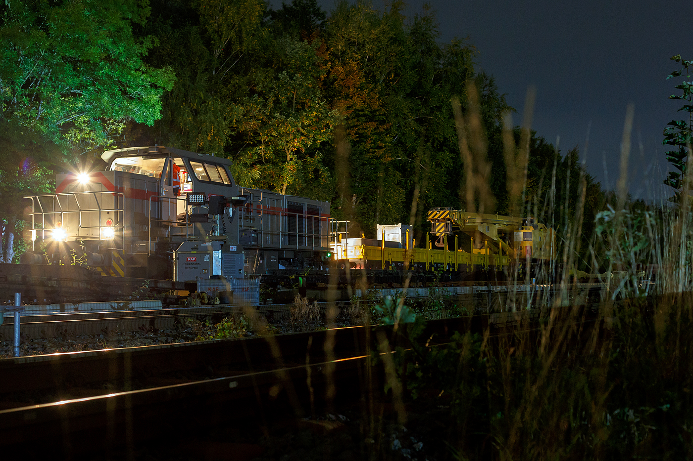 Die 271 006-9 „Julius“ (92 80 1271 006-9 D-KAF), eine Vossloh G 1000 BB, der KAF - Falkenhahn Bau AG (Kreuztal) hat am Abend des 10 Oktober 2025 auf Gleis 4, mit einem Kranzug der Hering Bahnbau, sowie mit einigen Flachwagen, den Bahnhof Herdorf erreicht. Hier sollen am Wochenende Weichen gewechselt werden.

Der Kranzug bestand aus dem 125 t KIROW Gleisbauschienenkran KIROW Multi Tasker KRC 810 T (mit Schwerlastausr�stung), D-HGUI 99 80 9419 024-1, ex 97 82 53 513 19-3, der HERING Bahnbau GmbH. Vor dem Kran der Schutzwagen auslegerseitig, 37 80 3999 048-6 D-HGUI, der Gattung Res, u.a. beladen mit der Traverse, Anschlagmittel und sonstiges Zubeh�r). Hinter dem Kran als Schutzwagen gegenlastseitig die vierachsige (2 x 2-achsige) lange Flachwageneinheit mit abgesenktem Fu�boden (ohne Radvorlegern) 27 80 4348 084-9 D-HGUI, der Gattung Laadkks (TWA 850 RV).
