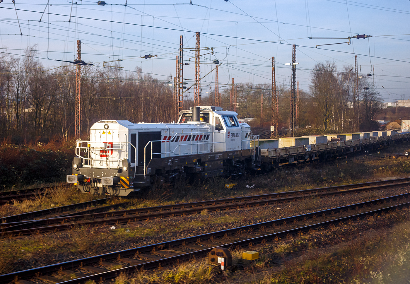 Die 4185 142-1 (92 80 4185 142-1 D-ERD) eine dieselelektrische Vossloh DE 18 der Eiffage Infra-Rail GmbH schient einen Bauzug am 21 Januar 2025 in den Abstellbereich (Schieneninfrastruktur) der Eiffage Infra-Rail GmbH in Herne (ehemals Heitkamp Rail GmbH). Bild aus einem IC heraus.

Die DE 18 wurde 2023 von der Vossloh Rolling Stock GmbH (teil der chinesischen CRRC-Gruppe) in Kiel unter der Fabriknummer 5502565 gebaut und im November 2023 an die Eiffage Infra-Rail GmbH in Herne geliefert, die in Deutschland 4 dieser DE 18 besitzt. 

Eiffage ist ein börsennotiertes französisches Bauunternehmen mit Firmensitz in Vélizy-Villacoublay. In Deutschland hat die Eiffage Infra-Rail GmbH ihren Sitz in Herne. Im Jahre 2010 übernahm Eiffage von Heijmans den Bereich Schieneninfrastruktur der ehemaligen Firma Heitkamp. Die Gleisbaugeräte und die zugehörige Werkstatt sind auf dem Gelände der ehemaligen Heitkamp Bauholding in Herne-Wanne beheimatet.

