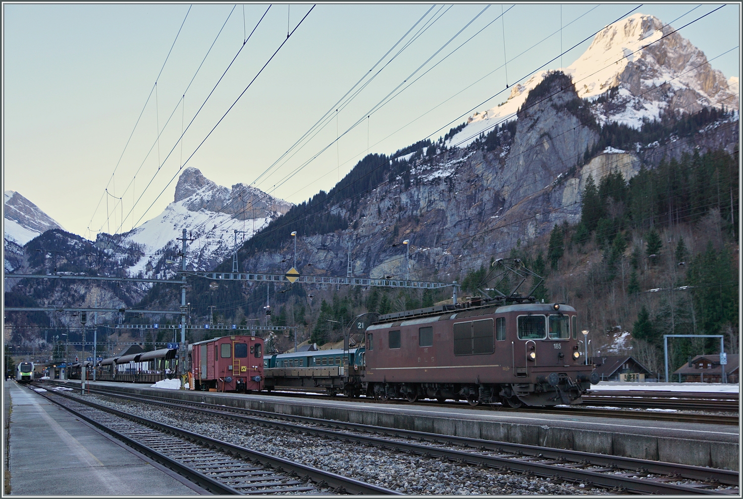 Die Autotunnelzüge der Strecke AT1 (und AT2 in der Hochsaiseon) nach Kandersteg (bzw. Iselle) sind im Bahnhof von Kandersteg fotografisch gesehen an einer sehr ungeschickt Stelle zu finden und somit kaum fotografier bar. Die Strecke bis zum Tunnel bietet jedoch gute Möglichkeiten, die letzten im Einsatz befindlichen BLS Re 4/4 zu fotografieren.
Ich blieb trotzdem an Bahnhof von Kandersteg und konnte die BLS Re 4/4 185 mit ihrem Autotunnelzug im Bahnhof fotografieren. Der Zug wartet auf die Abfahrt des BLS RABe 521 als R1 von Domodossola nach Bern, um dann als Dienstzug in Richtung Frutigen zu fahren. 

3. Jan. 2024