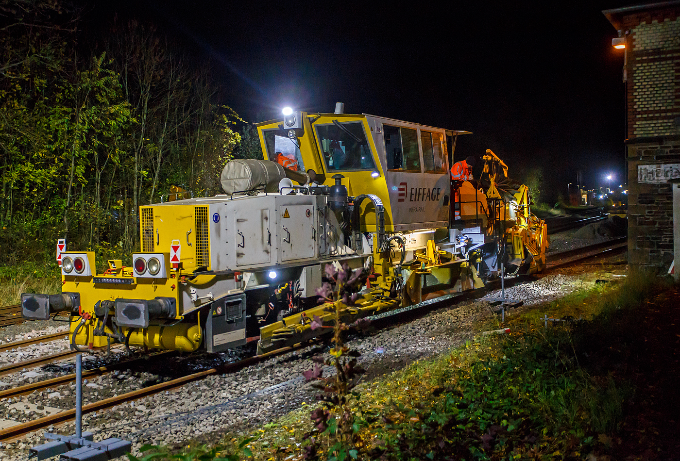 Die Baustelle Bahnhof Herdorf am Abend des 26 Oktober 2025 (ab 21:10 Uhr). Nach jedem Stopfdurchgang, wie hier von der P & T UNIMAT 09-4x4/4S E� (eine Nivelier-, Hebe-, Richt- und Universalstopfmaschine), der neuen Weiche 3 folgt eine Schotterplaniermaschine. So ist es hier die Schnell-Schotterplaniermaschine SSP 110 SW, D-ERB 99 80 9425 039-1 der Eiffage Infra-Rail GmbH (Herne), ex 97 16 40 546 17-4 der Heitkamp GmbH Herne (sp�ter Eiffage Rail), im Einsatz.

Der Schotterpflug wurde 1995 von der Deutschen Plasser unter der Fabriknummer 591 gebaut. 

TECHNISCEN DEATEN der Schotterplaniermaschine SSP 110 SW:
Spurweite: 1.435 mm (Normalspur)
Achsanzahl: 2
L�nge �ber Puffer: 17.230 mm
Achsabstand: 8.100 mm
Eigengewicht: 37 t
Anh�ngelast: 20 t
H�chstgeschwindigkeit: 90 km/h
Zugelassen zur Mitfahrt:  3 Personen
Kleinster befahrbarer Kurvenradius:  R 120 m      
Zugelassen f�r Streckenklasse: B1 und h�her