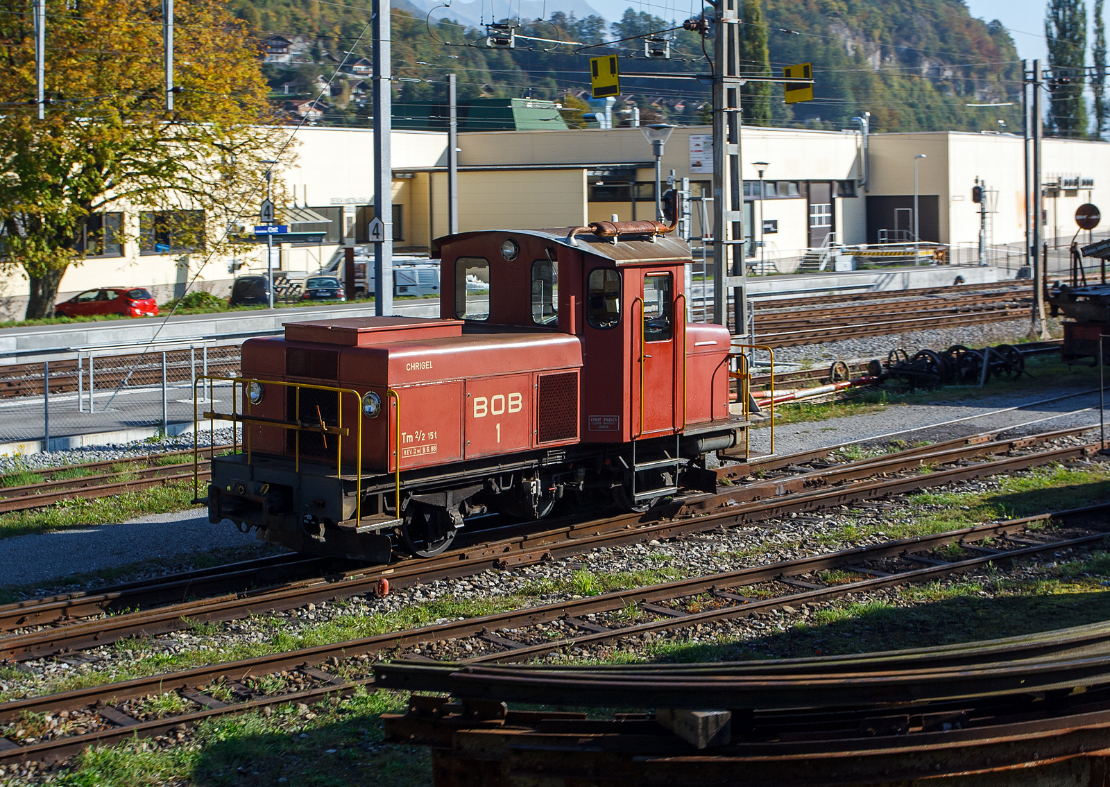 Die BOB dieselelektrische Rangierlok Tm 2/2 1 „CHRIGEL“  am 02.10.2011 vor dem Depot der Ballenberg Dampfbahn. Aufnahme aus einem fahrenden Zug.

Die Lok wurde 1946 von Ernst Stadler in Zürich gebaut, Zulieferer waren Saurer (Dieselmotor), BBC/MFO und SIG.

TECHNISCHE DATEN:
Spurweite: 1.000 mm
Achsfolge: B zz
Zahnstangensystem: Riggenbach
Länge: 6.860 mm
Breite: 2.720 mm
Höhe: 3.150 mm
Dienstgewicht: 15 t
Leistung: 120 kW
Höchstgeschwindigkeit: 30 km/h (35 km/h Schleppfahrt)