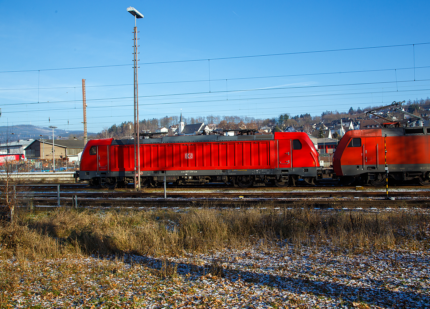Die DB Cargo 187 139-1(91 80 6187 139-1 D-DB) der DB Cargo AG ist am 15.12.2022 in Kreuztal in der Abstellgruppe abgestellt, davor ist die 152 015-4.

Die Bombardier TRAXX F140 AC3 wurde 2017 von der Bombardier Transportation GmbH in Kassel unter der Fabriknummer  35436 gebaut.  Die TRAXX F140 AC3 Varianten der DB Cargo (BR 187.1) haben keine Last-Mile-Einrichtung. Die Höchstgeschwindigkeit beträgt 140km/h. Die Lokomotiven können in gemischter Mehrfachtraktion mit BR185 und BR186 eingesetzt werden.
