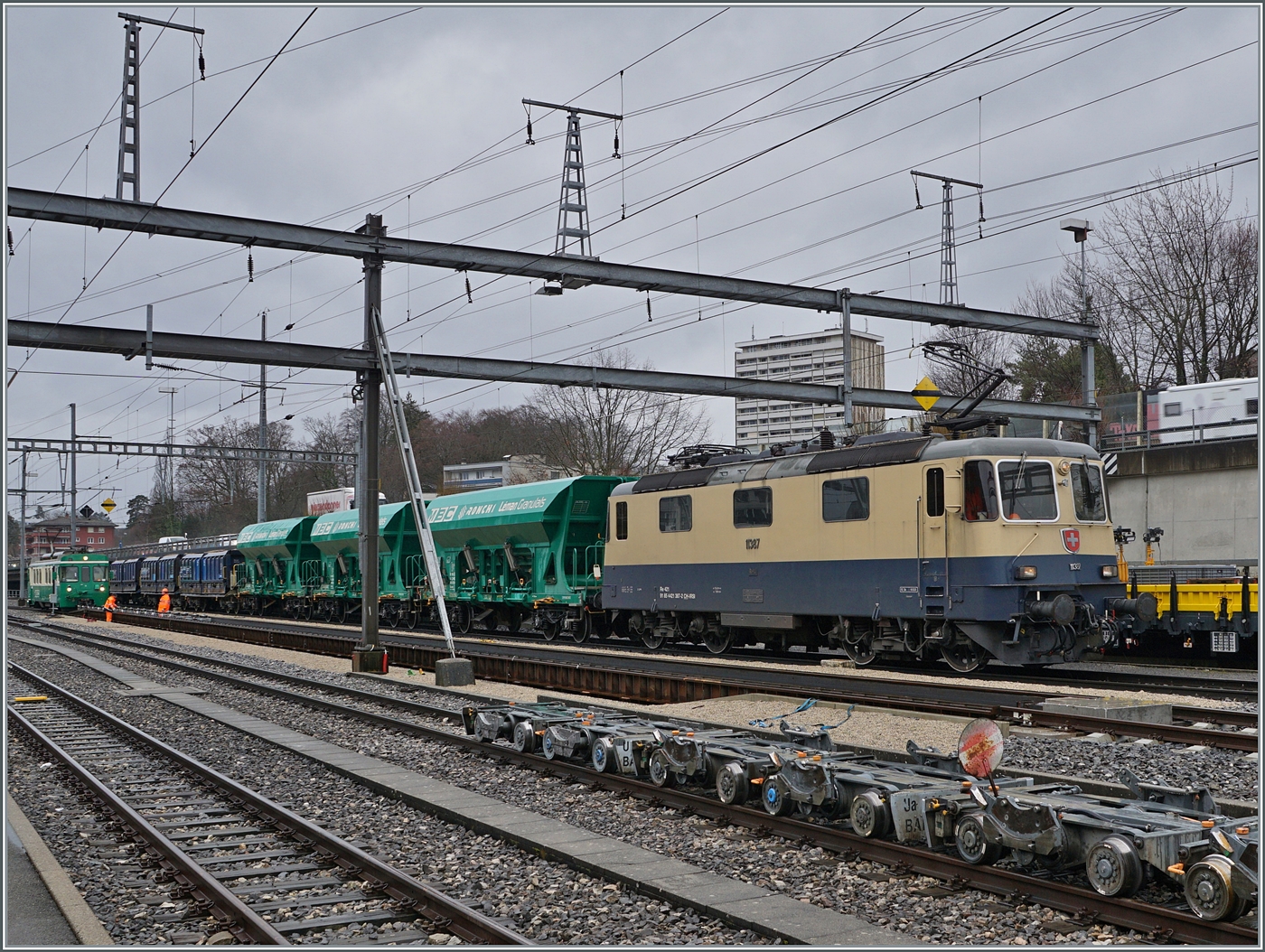 Die IRSI Re 4/4 II 11387 (Re 421 387-2) z.Z. im Dienste der BAM MBC schiebt in Morges  langsam ihrem Kieszug auf die Rollbockgrube. Der Güterzug wird in der Folge von den beiden BAM MBC Ge 4/4 21 und 22 für die Weiterfahrt nach Apples übernommen. 

22. Februar 2024 