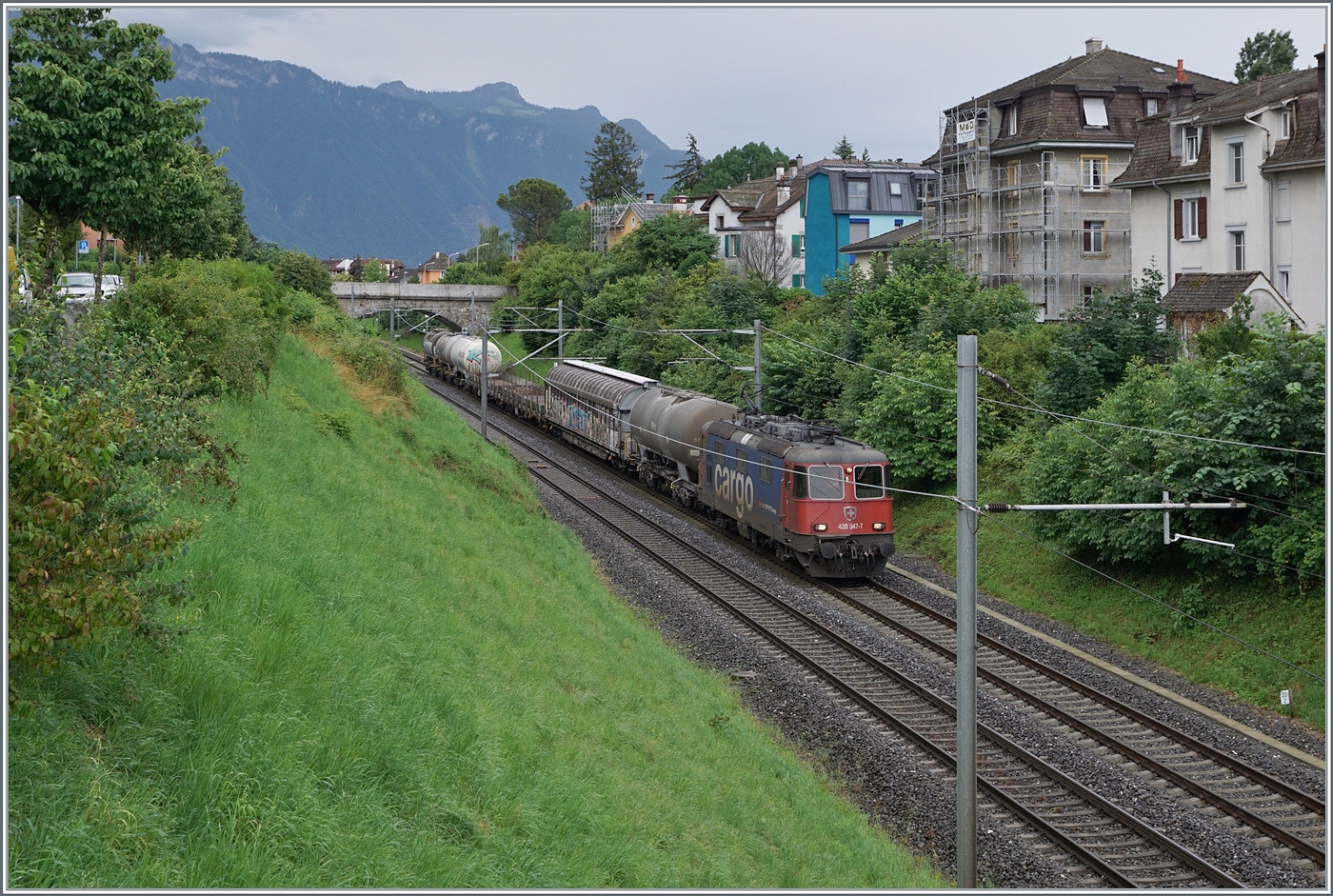 Die SBB Re 4/4 II 11341 (Re 420 341-7 ) ist mit einem kurzen Güterzug zwischen Burier und La Tour de Peilz auf der Fahrt in Richtung Lausanne. 

21. Juni 2024