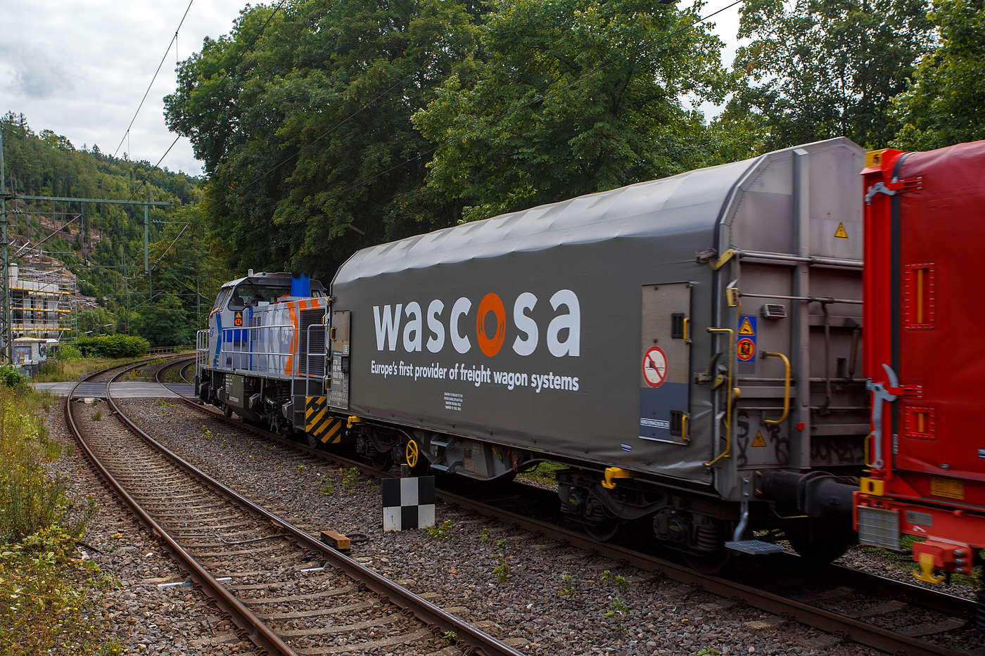 Direkt hinter der KSW 42 bzw. 277 902-3 (92 80 1277 902-3 D-KSW) der KSW (Kreisbahn Siegen-Wittgenstein), im Zugverband am 22 August 2025 in Kirchen/Sieg der vierachsiger Drehgestell-Flachwagen mit verschiebbarem Planenverdeck und Lademulden für Coil Transporte, 37 84 4668 170-2 NL-WASCO, der Gattung Shimmns, der WASCOSA AG. 