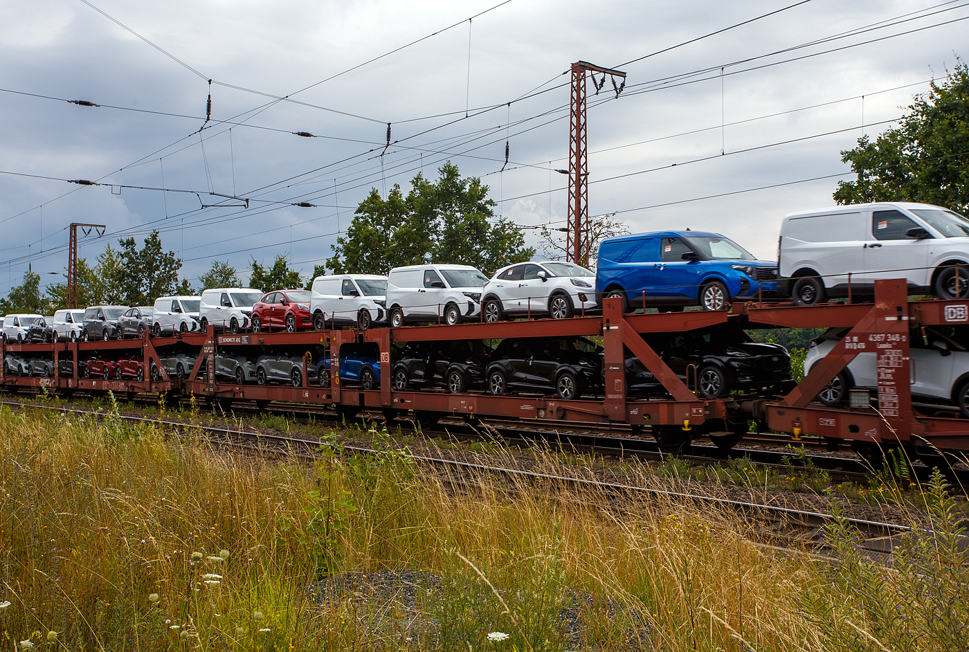 Doppelstock-Autotransportwagen 25 80 4367 693-5 D-ATG, der Gattung Laaeks 553, der DB Cargo Logistics GmbH (ex DB Schenker ATG) am 01 August 2024 im Zugverband bei der Zugdurchfahrt in Wilnsdorf-Rudersdorf (Kreis Siegen).

Der Wagen wurde 1988 von der Wagon Union (WU) in Berlin-Borsigwalde gebaut

Diese zuverlässigen und robusten Wagen dieser Bauarten wurden für den internationalen Transport von PKW entwickelt. Zur Be- und Entladung der oberen Ladeebene an Kopframpen können die Wagenenden aus der Transportstellung in die sogenannte Rampenstellung abgesenkt beziehungsweise angehoben werden. Des Weiteren können die Wagenenden der oberen Ladeebene in die Beladestellung angehoben werden. Hierdurch wird die maximale Durchfahrtshöhe für die Be- und Entladung der Fahrzeuge auf der unteren Ladeebene realisiert.

TECHNISCHE DATEN:
Gattung: Laaeks (Bauart 553)
Erstes Baujahr der Wagengattung: 1986
Spurweite: 1.435 mm
Anzahl der Achsen: 4
Länge über Puffer : 27.000 mm
Achsabstände: 9.000 / 4.300 / 9.000 mm
Ladelänge : 26.100 mm (unten) / 26.500 mm (oben)
Ladebreite : 3.000 mm (unten) / 2.910 mm (oben)
Wagenhöhe: 3.400 mm
Höchstgeschwindigkeit: 100 km/h (beladen) /120 km/h (leer)
Eigengewicht: 26.500 kg
Nutzlast: 18,5 t ab Streckenklasse A (unten max. 12 t / oben max. 10 t)
Kleinster befahrb. Gleisbogenhalbmesser: R = 80 m
Bremse: KE-GP (LL)
Bremssohle: IB 116
Intern. Verwendungsfähigkeit: RIV
