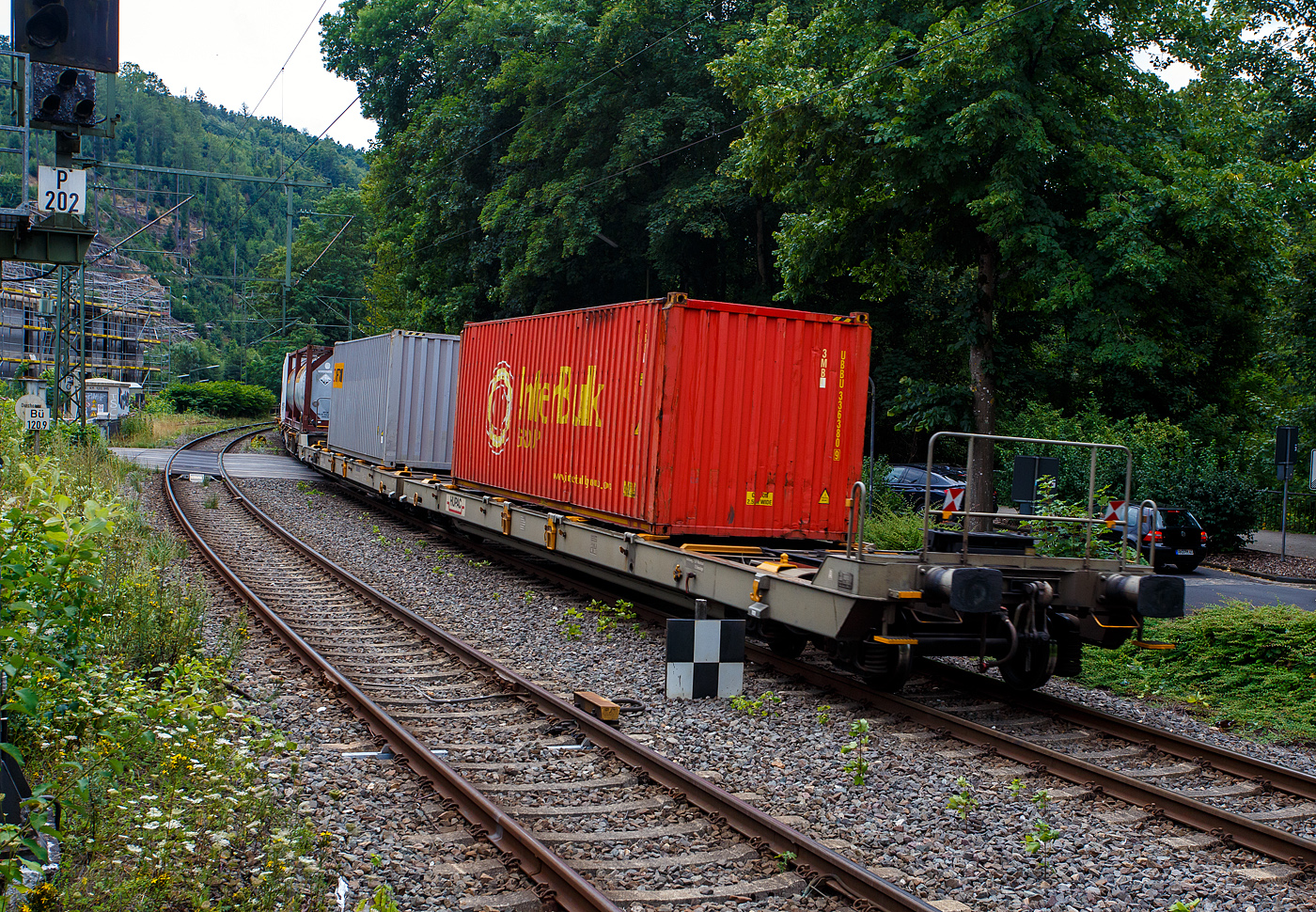 Eher ein Exot unter den Taschenwagen, der niedriggelegte achsachsige Doppelwagen Mega I, 33 85 459 6 036-5 CH-HUPAC, der Gattung Saadggns, der HUPAC Intermodal SA (Chiasso), am 01 August 2025 im Zugverband bei einer Zugdurchfahrt im Bahnhof Kirchen/Sieg, hier beladen mit zwei 30`-Container. Die Wageneinheit ist über eine sogenannte Kurzkupplung realisiert. So ist es einer 2x4-achsigen Wageneinheit, also vier Drehgestellen (acht Achsen) pro Wageneinheit.

Diese Wagen wurden in einer Serie von 45 Stück 1994 von der Ferriere Cattaneo SA in Giubiasco (Tessin/CH). Leider sind im Netz keine Datenblätter vorhanden, so kann ich den Wagen nur nach den Anschriften und eigener Sichtung beschreiben.

Diese Güterwagen sind zum Transport von kranmanipulierbaren Sattelaufliegern und genormten Wechselbehältern / Containern an allen europäischen Eisenbahnstrecken mit Normalspurweite bestimmt, auch bekannt als intermodaler Verkehr. Durch die niedrig gelegte Ladefläche können C 70-400 kodifizierte Jumbo-Wechselbehälter bis Norditalien und High-Cube-Container bis Süditalien auf der Gotthardstrecke transportiert werden.

TECHNISCHE DATEN:
Spurweite: 1.435 mm (Normalspur)
Länge über Puffer: 35.570 mm
Drehzapfenabstände: 13.300 mm /4.940 mm / 13.300 mm
Achsabstand in den Drehgestellen: 1.800 mm
Laufraddurchmesser: 840 mm (neu)
Ladelänge: 2 x 15.850 mm (ca. 2 x 52`)
Höhe der Ladeebene für Container/WB über SOK: 940 mm
Höhe der Tasche (für Sattelanhänger) über SOK: 270 mm
Eigengewicht: 33.000 kg
Max. Zuladung: 92,0 t (ab Streckenklasse A)
Max. Gewicht eines Sattelanhängers (je Wageneinheit): 38,5 t
Höchstgeschwindigkeit: 100 km/h (beladen) / 120 km/h (leer)
Bremse: O-GP-A (K) – 2 x 46 t
Bremssohle: Jurid 838 (Komposit-Bremssohlen)
Feststellbremse: Ja, jeweils an den mittleren Drehgestellen
Kleinster befahrbarer Gleisbogen: R 80 m
Verwendungsfähigkeit: RIV (Regolamento Internazionale Veicoli)

Die Bedeutung der Gattungs- und Kennbuchstaben (hier Saadggns):
S - Drehgestell-Flachwagen in Sonderbauart
aa - mit acht oder mehr Radsätzen
d - für den Transport von Straßenfahrzeugen eingerichtet
gg - für den Transport von Containern über 60 Fuß eingerichtet
n - mit sechs oder mehr Radsätzen höchste Lastgrenze über 75 
s - Höchstgeschwindigkeit (beladen) bis zu 100 km/h
