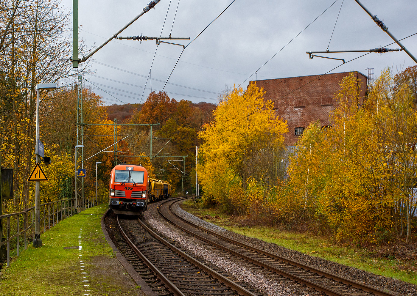 Es ist wie es ist, manchmal ist man einfach auf der falschen Gleisseite. Die 247 902 (92 80 1247 902-0 D-RTS) der RTS Rail Transport Service GmbH, Graz (eine 100%ige Tochter der Swietelsky Baugesellschaft m.b.H) fährt am 03 November 2025 mit einem P&T Schotterbewirtschaftungssystem BDS 2000-4 (eine Schotterverteilmaschine), sowie einer P&T UNIMAT 09-32/4S Dynamik (eine Universalstopfmaschine mit dynamischem Gleisstabilisator) am Haken durch Scheuerfeld/Sieg in Richtung Siegen. Beide Plasser & Theurer Maschinen gehören der Swietelsky Baugesellschaft m.b.H, wobei die BDS 2000-4 wohl in Österreich und die UNIMAT 09-32/4S in Deutschland eingesellt sind. 

Nochmals einen lieben Gruß an den netten Lokführer zurück.

Die Siemens Vectron DE wurde 2015 von Siemens Mobility GmbH in München-Allach unter der Fabriknummer 21762 als Vorführlok gebaut und eingestellt vom Siemens Prüfcenter Wegberg-Wildenrath als (92 80 1247 902-0 D-PCW). Für Testfahrten war sie bei einigen Bahnen. Ab 2017 war sie für die DB Cargo Deutschland AG (92 80 1247 902-0 D-DB) unterwegs, bis sie 2019 an die RTS - Rail Transport Service GmbH verkauft wurde. Zugelassen ist die Dieselelektrische Lok in Deutschland und Österreich, mit einer Höchstgeschwindigkeit von 160 km/h.
