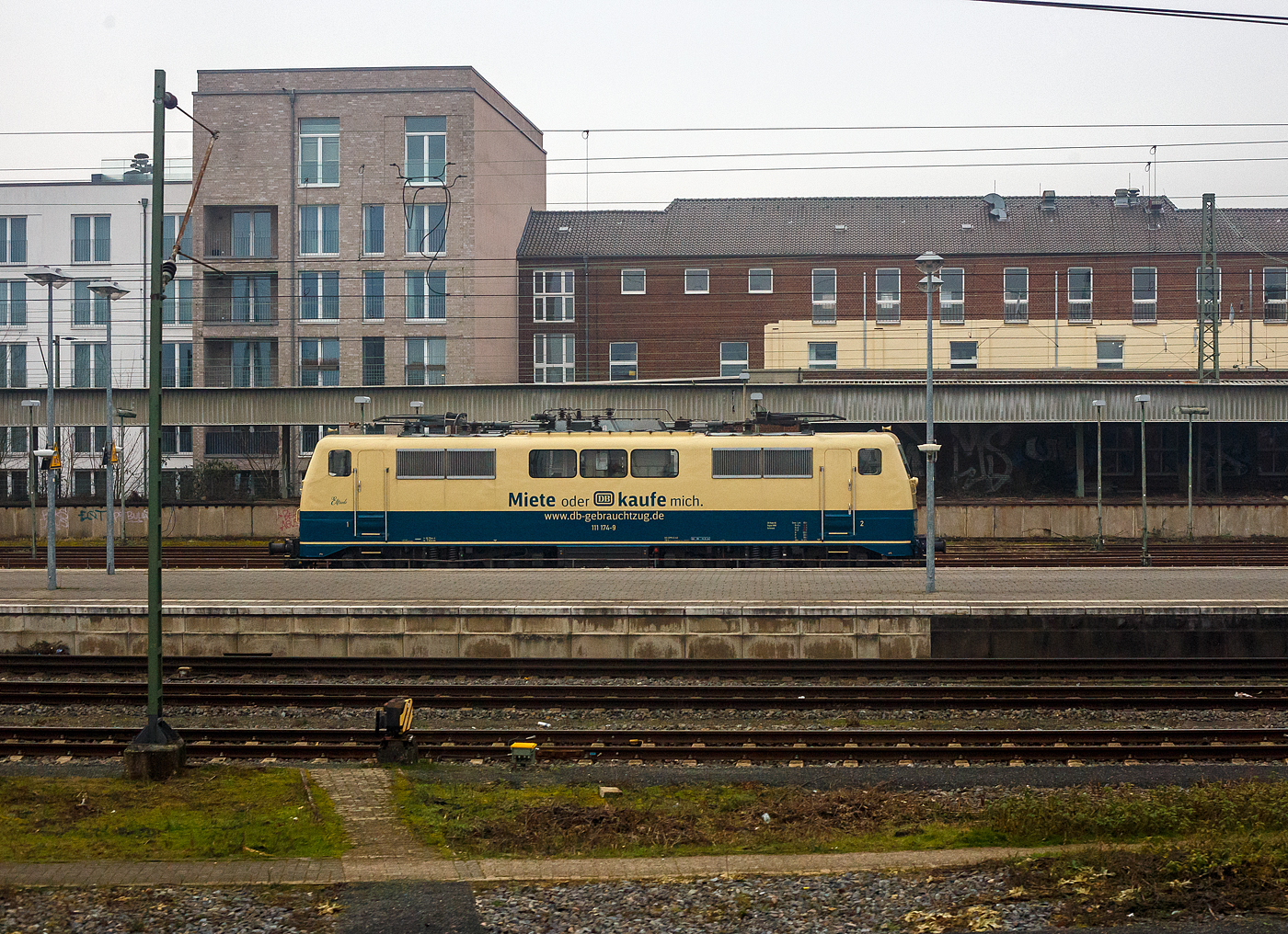 In ozeanblau/beige die 111 174-9 	(91 80 6111 174-9 D-DB) der DB Regio NRW (Fahrzeugnutzer ist die DB Gebrauchtzug - Miete oder kaufe misch) steht am 21 Januar 2025 beim Hbf Münster (Westfalen), die ich aus einem Zug ablichten konnte. 

Die Lok wurde 1981 von Henschel in Kassel unter der Fabriknummer 
32447 gebaut und an die Deutsche Bundesbahn geliefert.
