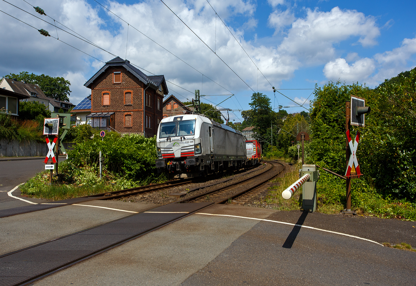 Meine erste SIEMENS Vectron mit 7 vor der 193, sowie eine ersten eigenen SIEMENS Vectron der TX Logistik AG, bisher hatte diese nur Loks angemietet. Die recht neue weiße TXL 7193 309 „Connected to Nature“ (91 80 7193 309-0 D-TXL) der TXL - TX Logistik AG (Troisdorf) fährt am 17 Juli 2025, mit einem KLV-Zug, durch Kirchen (Sieg), hier beim Bü km 121,192 in Richtung Betzdorf bzw. Köln.

Nochmals einen lieben Gruß an den netten Lokführer zurück.

Die SIEMENS Vectron MS (X4E) wurde 2024 von Siemens Mobility in München-Allach unter der Fabriknummer 23562 gebaut und am 03.01.2025 an die TXL ausgeliefert. Die mit 6.400 kW konzipierte Mehrsystemlok ist in der Variante A22-11i ausgeführt und hat so die und hat so die Zulassungen und entspr. Länderpakete für Deutschland, Österreich, Schweiz, Italien und die Niederlande (D / A / CH / I / NL).

Über TX Logistik AG
TX Logistik wurde 1999 als privates Eisenbahnverkehrsunternehmen gegründet und bietet mit Verbindungen in elf Ländern ein leistungsfähiges europäisches Netzwerk. Das Unternehmen verfügt über Tochtergesellschaften in der Schweiz, Österreich, Dänemark und Schweden sowie eine lokale Präsenz in Italien. In den Geschäftsbereichen Intermodal und Rail Freight entwickelt TX Logistik umfassende Schienenlösungen für kontinentale und maritime Verkehre sowie maßgeschneiderte Konzepte für konventionelle Fracht. Mit 650 Mitarbeitern und 8,6 Milliarden gefahrenen Tonnenkilometern erwirtschaftete das Unternehmen 2021 einen Jahresumsatz von 253 Millionen Euro. Seit Januar 2017 gehört TX Logistik zu 100 Prozent der Mercitalia Logistics S.p.A., einer Tochtergesellschaft der FS - Ferrovie dello Stato Italiane. Mittlerweile gehört das Unternehmen mit zu den Größten für den Schienengüterverkehr in Europa.

Das Unternehmen bietet den ganzen Umfang an Schienengüterverkehr, inklusive Containertransport und kombiniertem Verkehr an. Wichtigste Transportstrecken sind von den Häfen Hamburg, Bremerhaven, Rotterdam und Antwerpen nach Süddeutschland, Schweiz, Österreich und Italien.

TX Logistik setzt nun auf eigene Vectron Loks:
Anfang Oktober 2024 hat die TX Logistik AG ersten drei von 40 modernen Vectron-Lokomotiven des Herstellers Siemens Mobility aufs Gleis gesetzt, die das zur Mercitalia Logistics (FS Italiane Group) gehörende Schienenlogistikunternehmen im Mai 2023 bestellt hatte. Die Erweiterung der Fahrzeugflotte ist für TX Logistik eine wichtige Voraussetzung, um im intermodalen und grenzüberschreitenden Schienengüterverkehr weiter zu wachsen. Die neuen Lokomotiven werden vor allem auf dem Brenner- und dem Schweiz-Korridor eingesetzt, den strategisch wichtigen Nord-Süd-Achsen in Europa.

Beide Korridore sind stark frequentiert und stellen hohe Anforderungen an die eingesetzten Lokomotiven – von der Zugkraft über die Stabilität bis hin zur grenzüberschreitenden Systemkompatibilität. TX Logistik hat dazu die Maschinen mit verschiedenen Länderpaketen bestellt. 20 Vectron erhalten das Länderpaket für den Betrieb in Deutschland, Österreich, Schweiz, Italien und den Niederlanden (D-A-CH-I-NL) und sollen bis Anfang 2025 übergeben werden. Die Auslieferung der 20 Lokomotiven mit der Ausstattung für den deutsch-österreichisch-italienischen Korridor (D-A-I) soll bis zum Jahresende 2025 erfolgen.

Die Entscheidung für den Kauf der Vectron-Lokomotiven unterstreicht zugleich das Bestreben von TX Logistik, Schienengüterverkehre als umweltfreundliche und effiziente Alternative zum Straßentransport weiter voranzutreiben. Um dies zu unterstreichen und gleichzeitig für den Einstieg in den intermodalen Transport zu werben, hat die erste der drei Vectrons, die im Zughotel in Braunschweig übergeben wurden, eine spezielle Lok-Beklebung mit dem Schriftzug „Start now (Nature). Driven by Green Passion“ erhalten.

Die neuen Loks bieten mit ihrer Flexibilität und Leistungsfähigkeit ideale technische Voraussetzungen, um den steigenden Anforderungen des europäischen Güterverkehrs gerecht zu werden. Mit der modernen Vectron-Flotte, so TX Logistik, sei man mittelfristig nun in der Lage, die Kapazitäten auf dem Brenner- und dem Schweiz-Korridor deutlich zu erhöhen sowie die Effizienz und Zuverlässigkeit im Schienengüterverkehr weiter zu verbessern.
