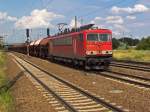 155 107 durchfährt mit einem Ganzzug aus Selbstentladewagen den Bahnhof Schönefeld.