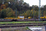 Ein Drehgestell-Flachwagen, Nummer unbekannt, der Gattung Res als Kran-Schutzwagen gegenlastseitig, u.
