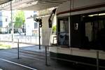 Straßenbahn / Stadtverkehr Augsburg; ein Combino in der Haltestelle Hauenstetter Straße; im Boden vor der Tram ist eine im Boden eingelassene Fußgängerampel für Handynutzer.