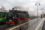 Die sächsische VII K (Altbau) Dampflok 99 1761-6 rangiert am 07 Dezember 2022 im Schmalspur-Bahnhof Radebeul Ost, um sich gleich vor, unseren Zug, den Lößnitzdackel (Lößnitzgrundbahn) für die Abfahrt in Richtung Moritzburg, zusetzen. 

Die 750 mm-schmalspurige Dampflok der Altbau-Baureihe 99.73-76 wurde 1933 von der BMAG - Berliner Maschinenbau-Actien-Gesellschaft vormals L. Schwartzkopff in Berlin unter der Fabriknummer 10152 gebaut und als 99 761an die DRG - Deutsche Reichsbahn-Gesellschaft geliefert.

Weitere Lebenslauf und Nummerierungen:
1933 bis 1970 - DRG / DRB / DR 99 761 
1970-1992 - DR 99 1761-8 
1992-1994 - DR 099 734-6 
1994-2004 - DB 099 734-6 
2004-2007 - BVO 99 1761-8 (Busverkehr Ober- und Westerzgebirge Bahn GmbH)
seit 2007- SDG 99 1761-8 (Sächsische Dampfeisenbahn Gesellschaft mbH)
Im Jahr 1964 bekam sie im Raw Cottbus einen Neubaukessel (Baujahr 1964, Fabriknummer 15).

Die 5-fach-gekuppelten Lokomotiven der Baureihe 99.73–76 waren Einheitslokomotiven der Gattung K 57.9  der Deutschen Reichsbahn für die sächsischen Schmalspurbahnen. Zusammen mit der Nachfolgebauart Baureihe 99.77–79 stellen die Lokomotiven die stärksten Schmalspurlokomotiven für 750 mm-Spurweite in Deutschland dar.

Obwohl mit der fünffach gekuppelten Baureihe 99.67–71 schon eine recht leistungsfähige Lokomotive für den Betrieb auf den Gebirgsstrecken im Erzgebirge vorhanden war, bestand auch weiterhin Bedarf an einer besonders leistungsstarken Bauart. So gelang es der neu gegründeten Reichsbahndirektion Dresden, die Beschaffung einer Einheitslokomotive für 750 mm-Spur durchzusetzen. Das Vereinheitlichungsbüro der Deutschen Lokomotiv-Vereinigung in Berlin-Tegel erarbeitete den Entwurf für die Konstruktion.

Die erste Serie von 13 Lokomotiven fertigte die Sächsische Maschinenfabrik vormals Richard Hartmann in Chemnitz. Laut Liefervereinbarung sollte die Sächsische Maschinenfabrik noch weitere Loks liefern, durch den Konkurs und die Liquidation des Unternehmens 1930 ging dieser Auftrag an die Berliner Maschinenbau AG vormals Schwartzkopff (BMAG) über. 1928 wurden sieben und 1933 noch weitere zwölf Lokomotiven von der BMAG geliefert. Die damals hochmodernen Lokomotiven entsprachen in ihrer Konstruktion den regelspurigen Einheitslokomotiven. Die Lokomotiven erfüllten die Erwartungen. Mit Vorspann war es nun möglich, auch überlange Schmalspurzüge mit bis zu 56 Achsen bergwärts zu befördern.

1945 mussten zehn Lokomotiven als Reparationsleistung an die Sowjetunion abgegeben werden. Zudem erhielten die Loks dort auch einige, bauliche Änderungen. Die hintere Laufachse wurde entfernt, und sie wurden alle auf Ölfeuerung umgebaut und mit Schlepptendern ausgerüstet. Zwischen 1975 und 1979 wurden alle Maschinen der UdSSR ausgemustert. Es waren die Loks 733, 736, 737, 744, 748, 751, 752, 753, 755 und 756. Demgegenüber stand eine enorme Zunahme der Verkehrsleistung auf den Schmalspurbahnen im Erzgebirge durch den neu aufgenommenen Uran-Bergbau der SDAG Wismut. Um dem daraus resultierenden Lokomotivmangel abzuhelfen, entstand ab 1952 eine ähnliche Nachfolgebauart beim VEB Lokomotivbau Karl Marx in Babelsberg als Baureihe 99.77–79.

Ende der 1960er Jahre mussten wegen Schäden an den Kesseln die ersten Lokomotiven ausgemustert werden. Zehn Lokomotiven erhielten neue, geschweißte Kessel und wurden auch weiterhin auf ihren Stammstrecken eingesetzt. Die 99 1760 wurde 1992 auf Ölhauptfeuerung umgebaut.

Technische Merkmale:
Die fünffach gekuppelten Lokomotiven haben einen Barrenrahmen und verfügen über in Bisselgestellen gelagerte Laufachsen. Als Treibachse dient die fest gelagerte dritte Achse, welche anfangs geschwächte Spurkränze aufwies. Nach 1945 wurden die Spurkränze dann völlig entfernt, um die Bogenläufigkeit weiter zu verbessern. Die zweite und die fünfte Kuppelachse waren seitenverschiebbar. Der feste Achsstand betrug anfangs 3.000 Millimeter, wurde dann aber später auf 4.000 Millimeter verlängert. Wie für alle Einheitslokomotiven typisch, wurden die Lokomotiven 99 731 bis 99 750 mit Kolbenspeisepumpe und einen quer über der Rauchkammer eingebauten Knorr-Oberflächenvorwärmer geliefert. Die 99 751 bis 99 762 wurden dagegen mit Abdampfinjektor Bauart Friedmann geliefert, später jedoch ebenfalls auf Knorr-Vorwärmer umgebaut. Die zweite Kesselspeisevorrichtung ist eine saugende Dampfstrahlpumpe. Der Langkessel bestand aus zwei Schüssen.

Wegen der damals noch teilweise gebräuchlichen Heberleinbremse erhielten die Lokomotiven ab Werk auch die dafür erforderliche Ausrüstung mit Rollenführungen und Haspel. Die Lokomotive selbst bekam eine Knorr-Druckluftbremse, welche über die Saugluftbremse für den Wagenzug angesteuert wird. Als die ersten Lokomotiven 1928 ausgeliefert wurden, war schon geplant, die veraltete Trichterkupplung durch die Scharfenbergkupplung abzulösen. So erhielten die ersten Lokomotiven zunächst Trichterkupplungen. Diese wurden später problemlos gegen die neuen Kupplungen getauscht.

TECHNISCHE DATEN:
Bauart:  1’E1’ h2t
Gattung:  K 57.9
Spurweite:  750 mm
Länge über Kupplung:  10.540 mm
Höhe:  3.570 mm
Fester Radstand:  4.000 mm
Gesamtradstand:  7.600 mm
Kleinster befahrbarer Radius:  50m
Leergewicht:  44,3 t
Dienstgewicht:  56,7 t
Reibungsmasse:  46,1 t
Höchstgeschwindigkeit:  30 km/h
Indizierte Leistung:  600 PSi, 441 kW
Anfahrzugkraft:  83,35 kN
Steuerungsart:  Heusinger
Zylinderanzahl:  2
Kesselüberdruck:  14 bar
Wasservorrat:  5,80 m³
Brennstoffvorrat:  2,5 t Kohle
Lokbremse:  Knorr-Druckluftbremse, ursprünglich saugluftgesteuert, mit Zusatzbremse
Zugbremse:  Körting-Saugluftbremse, anfangs Heberleinbremse, heute Knorr-Druckluftbremse
Zugheizung:  Dampf
Kupplungstyp:  Scharfenbergkupplung