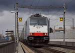 Mit gesenktem Stromabnehmer fährt 186 251 über die Netz-Trennstelle auf der Verbindungsbahnbrücke in Basel.