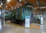 Die Drehstrom- Elektrolokomotive ex BTB De 2/2 Nr.1, ex BTB F 2/2 Nr. 1 (1902 – 1922), ex BTB E2E Nr. 1 (bis 1902), am 11.09.2022 in der Lokwelt Freilassing. Die Lok ist Eigentum des Deutschen Museums - Verkehrszentrum in M�nchen und eine Leihgabe die Lokwelt Freilassing

Dem G�terverkehr der Burgdorf-Thun-Bahn (BTB) dienten zwei Lokomotiven vom Typ F 2/2. Bis 1902 wurden sie als E2E bezeichnet, ab 1922 als De 2/2. Diese beiden ersten in der Schweiz, im Jahr 1899, gebauten elektrischen Lokomotiven (De 2/2 Nr.1 und  2) waren eine gemeinsame Konstruktion der Schweizerischen Lokomotiv- und Maschinenfabrik (SLM) in Winterthur f�r den mechanischen Teil und der Brown, Boveri & Cie. (BBC) f�r die elektrische Ausr�stung. 

Der noch nicht ausgereifte Einphasen-Wechselstrom-Betrieb konnte zur damaligen Zeit noch nicht eingesetzt werden. Deshalb beschaffte die Schweizer Burgdorf-Thun-Bahn (BTB) zun�chst f�r den reinen G�terzugbetrieb zwei dieser mit Drehstrom (Dreiphasenwechselstrom) angetriebenen Lokomotiven. Das Drehstrom-System konnte nur in einem bestimmten Geschwindigkeitsbereich effektiv arbeiten, so dass ein mechanisches Schaltgetriebe f�r zwei maximale Geschwindigkeiten notwendig war, n�mlich f�r 18 und 36 km/h.

Ab 1933 wurde der Drehstrombetrieb auf dieser Strecke eingestellt und die beiden Lokomotiven ausgemustert. Die beiden Lokomotiven sind als weltweit erste Drehstromlokomotiven f�r den Vollbahnbetrieb erhalten geblieben. Die Nr. 1 befindet in der Lokwelt Freilassing, die Nr. 2 befindet sich im Verkehrshaus der Schweiz in Luzern.

Die beiden Motoren wiesen eine Leistung von je 150 PS (110 kW) auf. Das nur im Stillstand umschaltbare Getriebe erm�glichte zwei Geschwindigkeiten, Die eine bis 18 km/h lie� auf der gr��ten Steigung von 25 ‰ eine Anh�ngelast von 100 Tonnen zu, die andere bis 36 km/h noch die H�lfte. Wobei die zul�ssige H�chstgeschwindigkeit betrug 50 km/h, so wurde in den sp�teren Betriebsjahren in Gef�llen stromlos gefahren, um diese zu erreichen. Dank der h�heren Geschwindigkeit h�tten die Lokomotiven n�tigenfalls auch im Personenverkehr Verwendung finden k�nnen.

Die beiden 19-poligen Triebmotoren sind beidseits auf einer auf einem Hilfsgestell gelagerten gemeinsamen Welle montiert. �ber ein Vorgelege wurde das Drehmoment mittels Kuppelstangen auf die beiden Achsen �bertragen. Zum Anfahren war ein f�r beide Motoren gemeinsamer Widerstand vorhanden, der mit dem in jedem F�hrerstand vorhandenen Kontroller allm�hlich ausgeschaltet wurde. Beleuchtung, Heizung und Hilfsbetriebe wurden mit einer Spannung von 100 Volt betrieben. Die Lokomotiven weisen an beiden Enden offene Plattformen auf. Die vier Schleifb�gel auf dem Dach legten sich selbstt�tig beim Wechsel der Fahrtrichtung nach hinten um. Zum Abb�geln mussten die an den B�geln angebrachten kurzen Zugseile vom Boden aus mit h�lzernen Stangen heruntergezogen und in Arretierhaken eingeh�ngt werden.

TECHNISCHE DATEN:
Baujahr: 1899, Ausmusterung1930
Spurweite: 1.435 mm (Normalspur)
Achsfolge: B
L�nge �ber Puffer: 7.800  mm
Achsabstand: 3.140 mm
Treibraddurchmesser:  1.230 mm
Dienstgewicht: 29.600 kg
H�chstgeschwindigkeit: 18 km/h / 36 km/h (stromlos bergab 50 km/h)
Stundenleistung: 300 PS (220 kW)
Stundenzugkraft: 4.400 daN
Stromsystem: 750 V, 40 Hz ∆
Anzahl der Fahrmotoren: 2
�bersetzungsstufen: 2 (f�r 18 / 36 km/h)

Die Burgdorf-Thun-Bahn (BTB) war eine Eisenbahngesellschaft in der Schweiz. Ihre Strecke von Burgdorf �ber Konolfingen nach Thun wurde als erste elektrische Vollbahn der Schweiz im Jahr 1899 dem Betrieb �bergeben. Heute ist sie Bestandteil der BLS AG