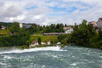   Während tobend die Wassermassen den Rheinfall bei Schaffhausen herab stürzen, zieht die SBB Cargo Re 620 060-4   Tavannes  (ex SBB Re 6/6 11660   Tavannes  ) am 18.06.2016 einen Holcim