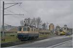 Die von Morges gekommene IRSI/IGE  Rheingold  Re 4/4 II 11387 (Re 421 387-2) hat in Gland die Strecke nach Genève verlassen und fährt nun über ein Industriegleis in Richtung Kieswerk,